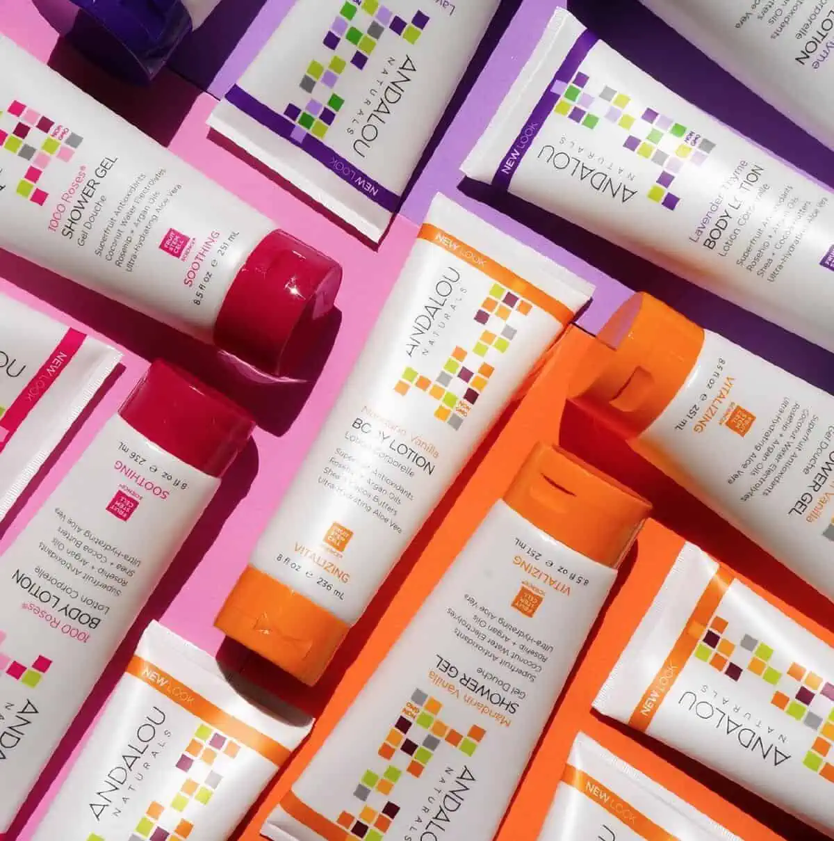 A puzzle arrangement of Andalou Naturals body lotions and shower gels on a hot pink background.