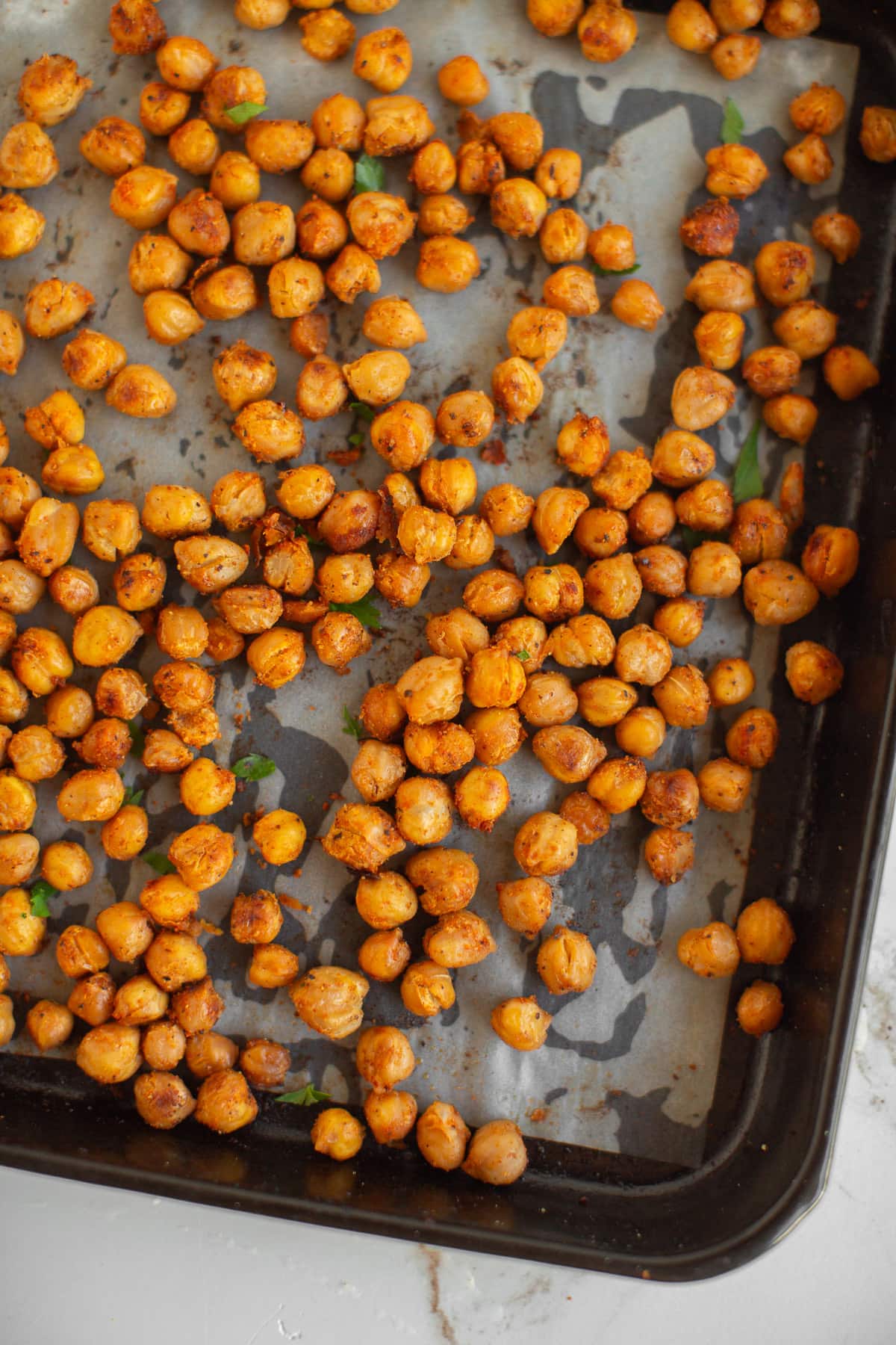 Roasted chickpeas on a baking sheet, a healthy vegan snack option.