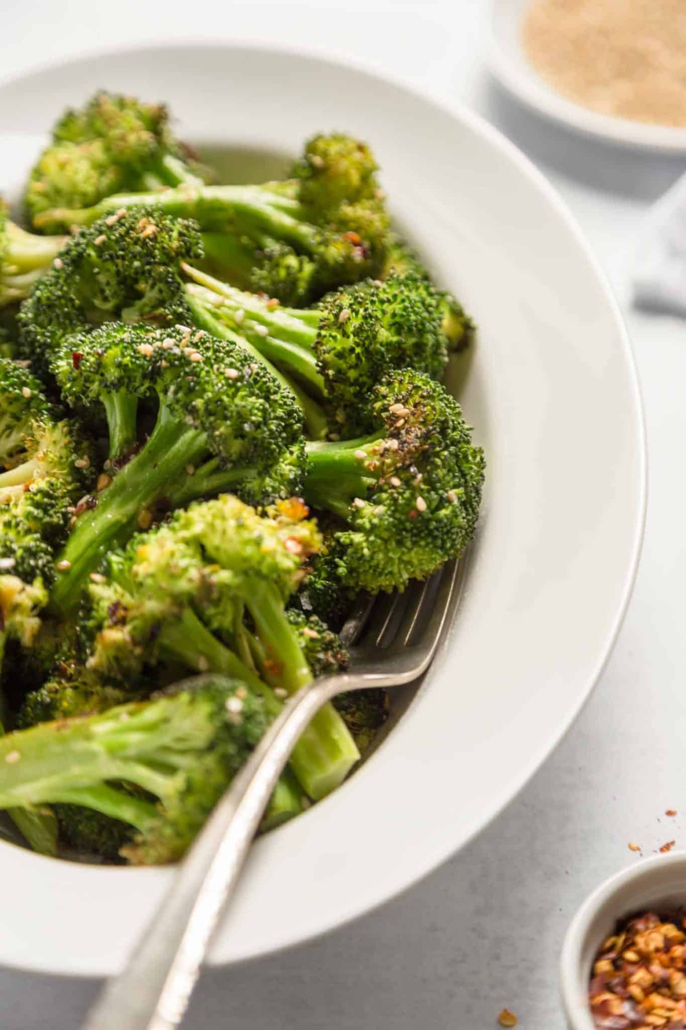 An dish filled with crispy broccoli bites and serving spoon.