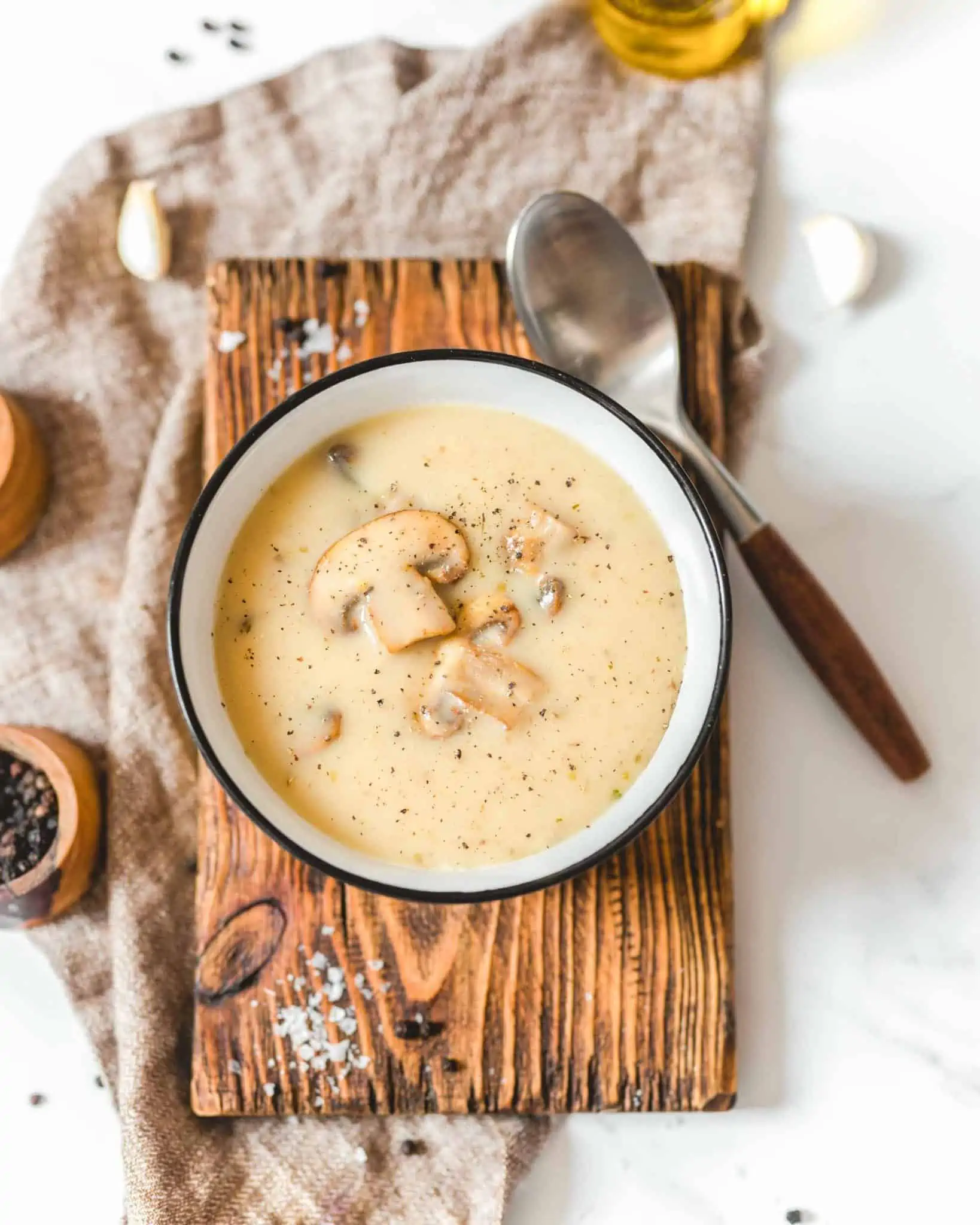Vegan cashew cream of mushroom soup in a bowl on a wooden board.