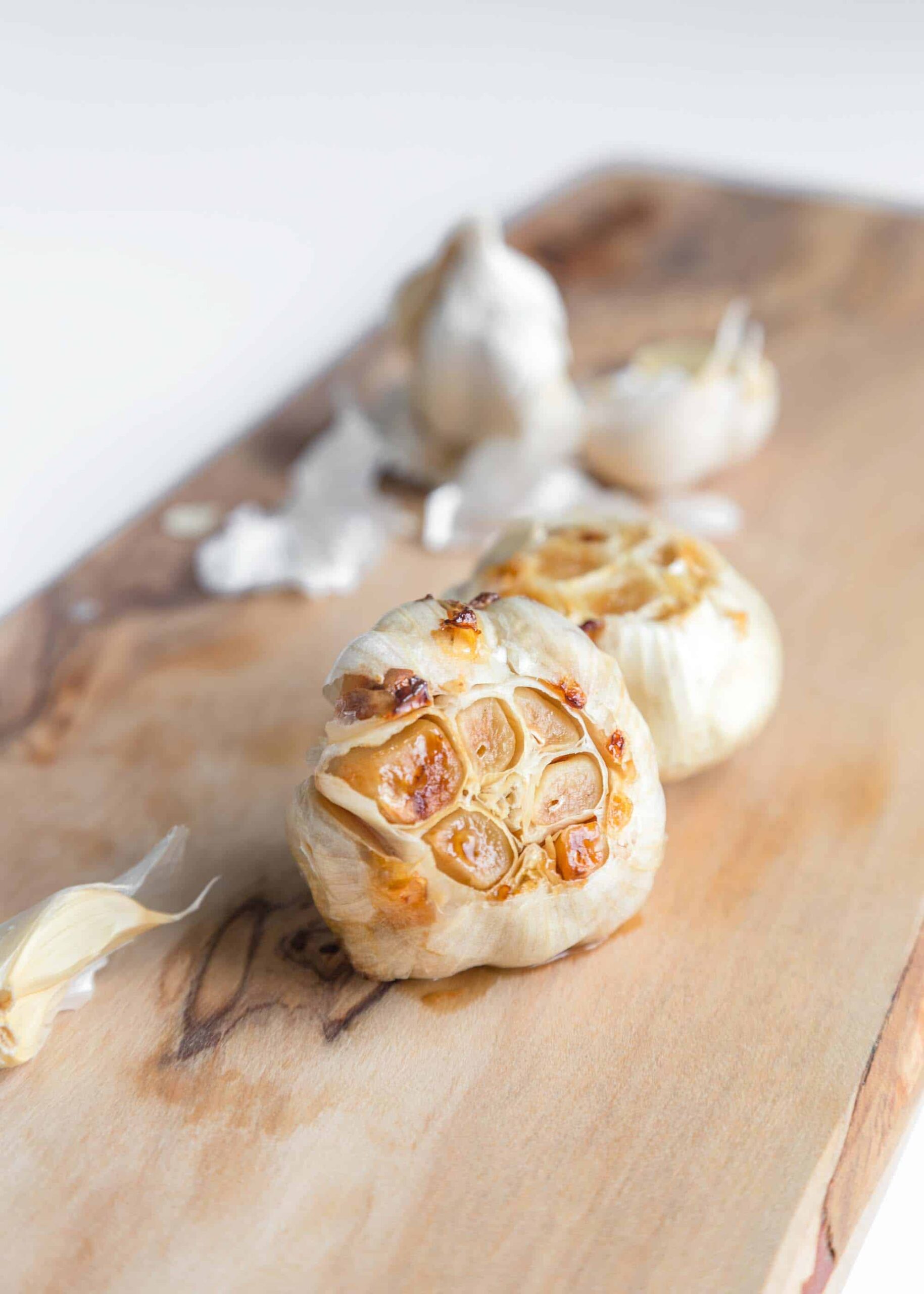 A head of roasted garlic on a cutting board.