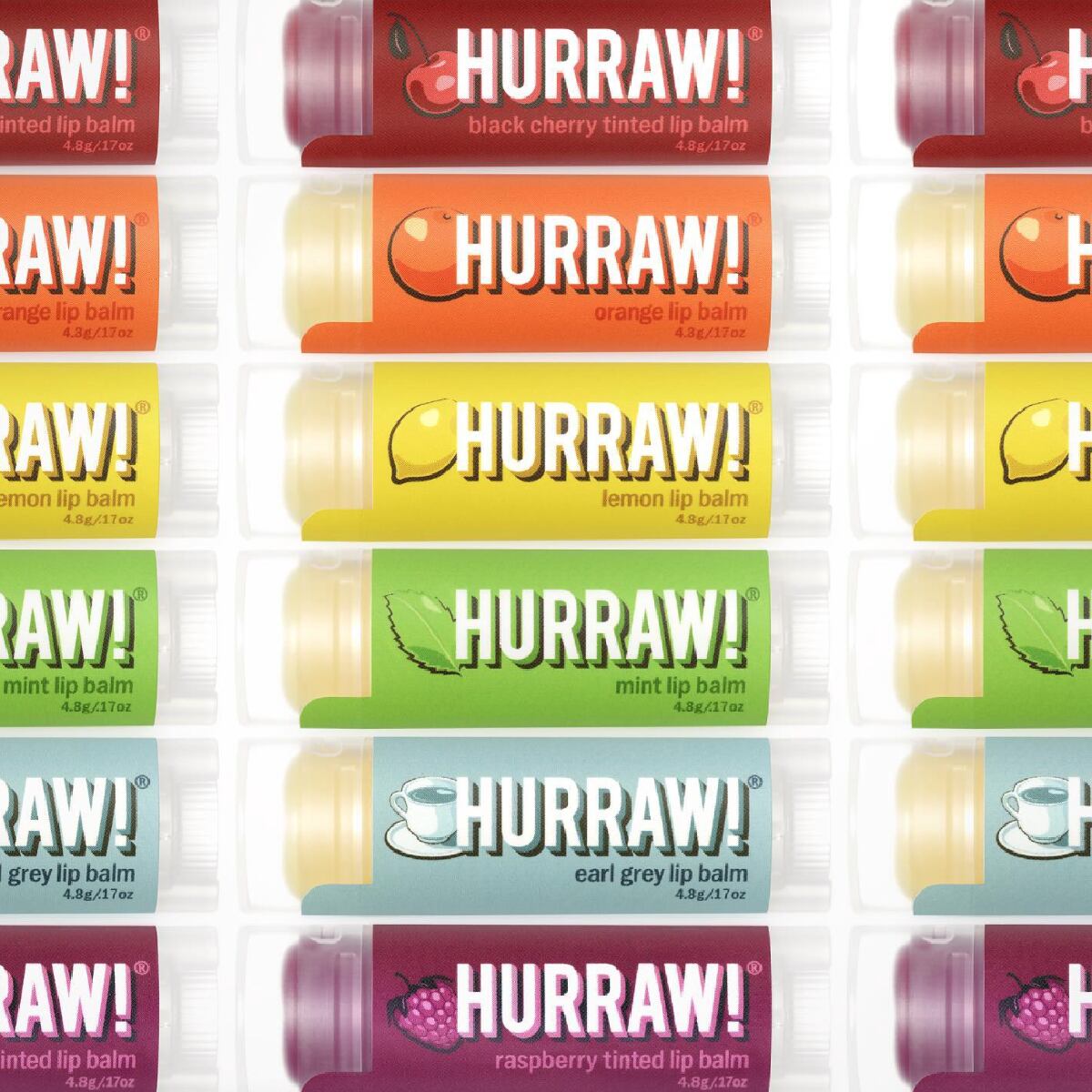 Three vertical columns of Hurraw! vegan lip balms in rainbow color against a white background.