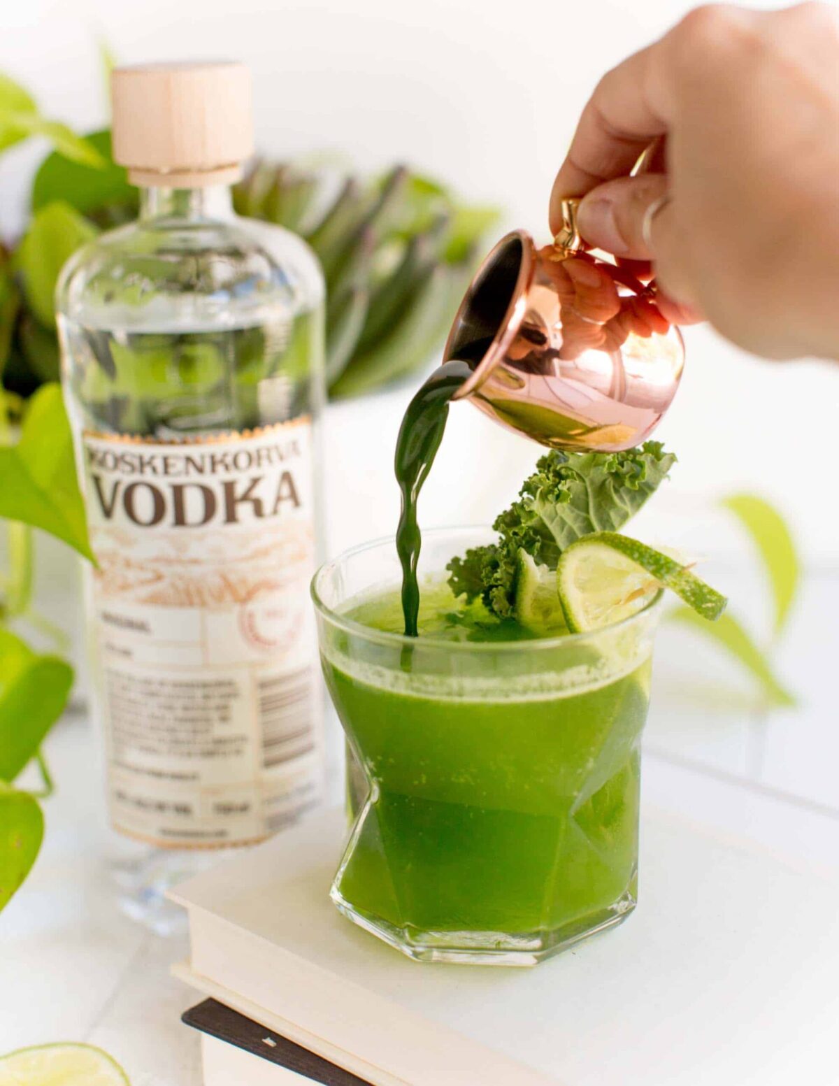 Kale juice being added to a cocktail.