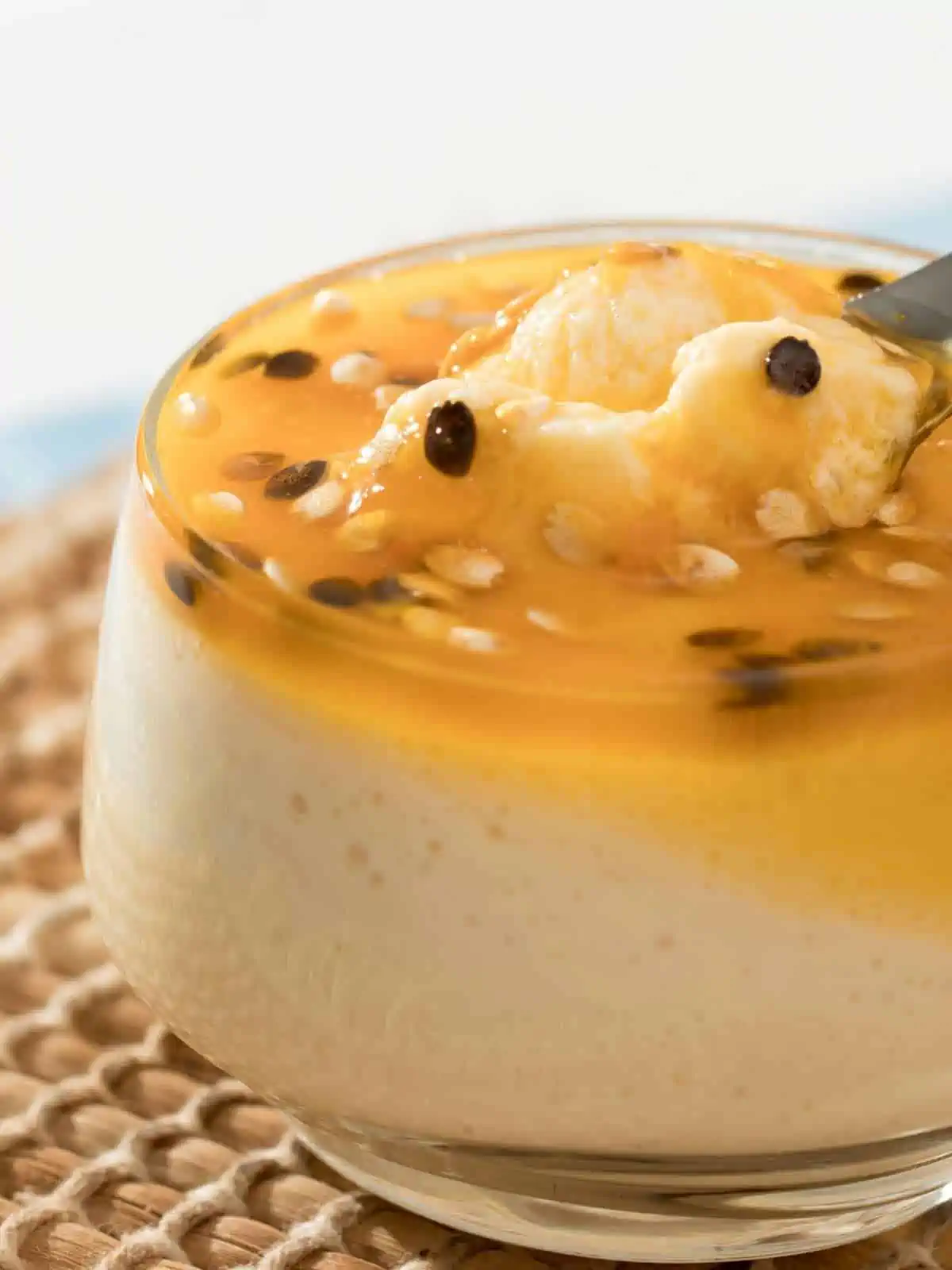 Lilikoi mousse in a glass with a spoon lifting some up.