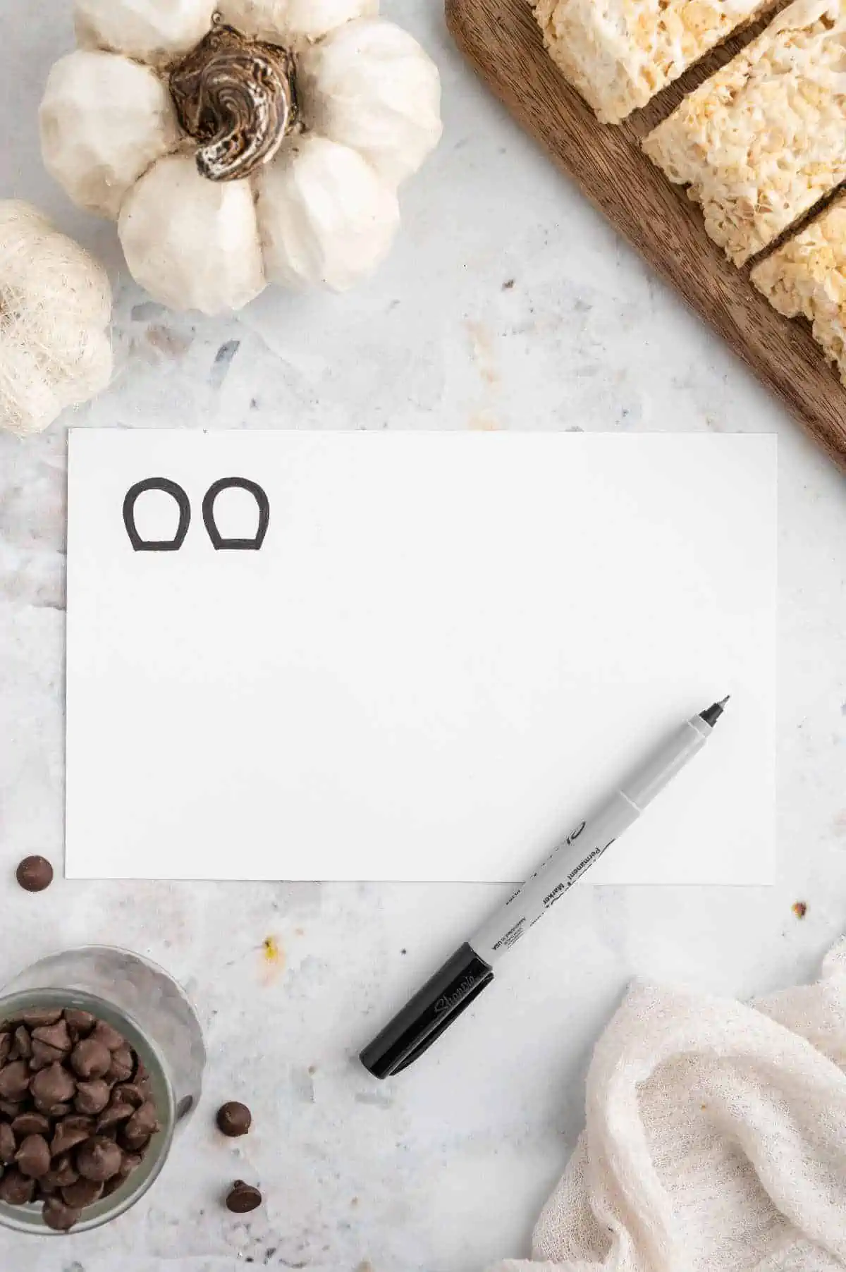 Sketch of mice ears on paper with a black marker.