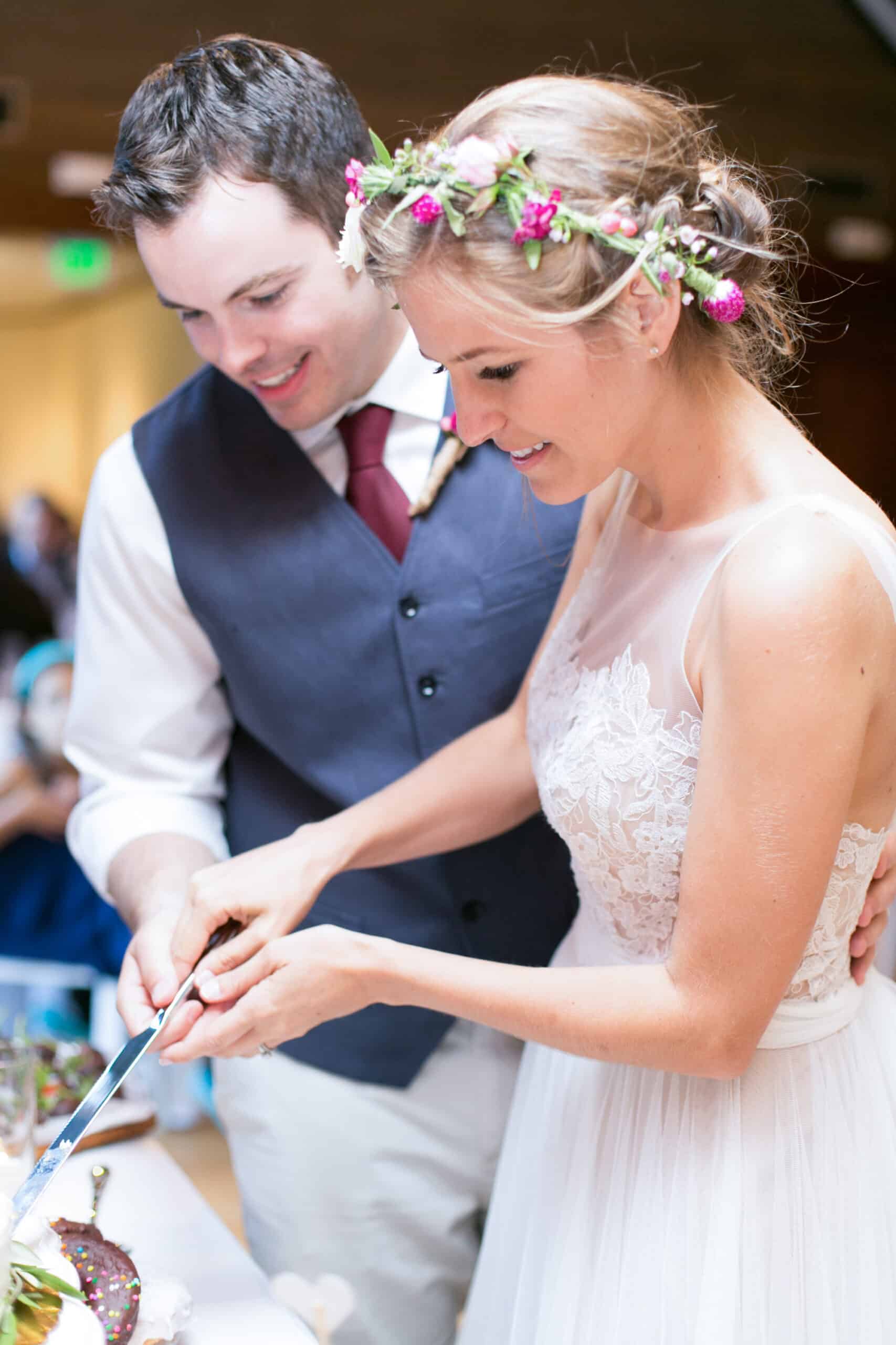 Bride and groom cutting their vegan wedding cake together.