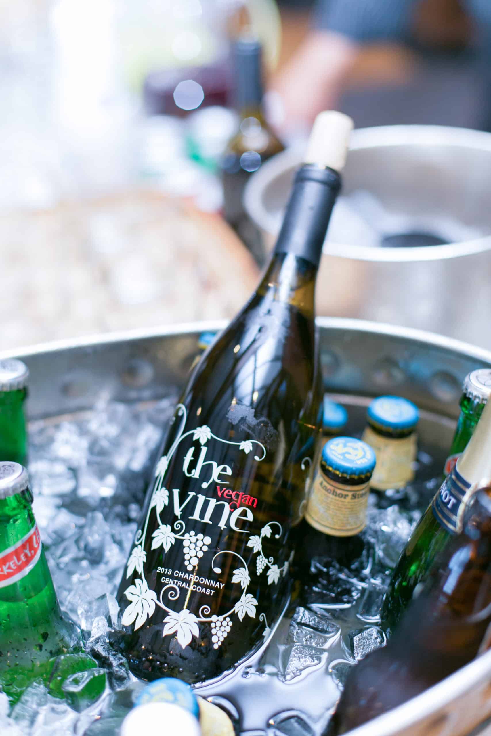 Bottle of The Vegan Vine wine chilling in an ice bucket with other drinks at a vegan wedding.
