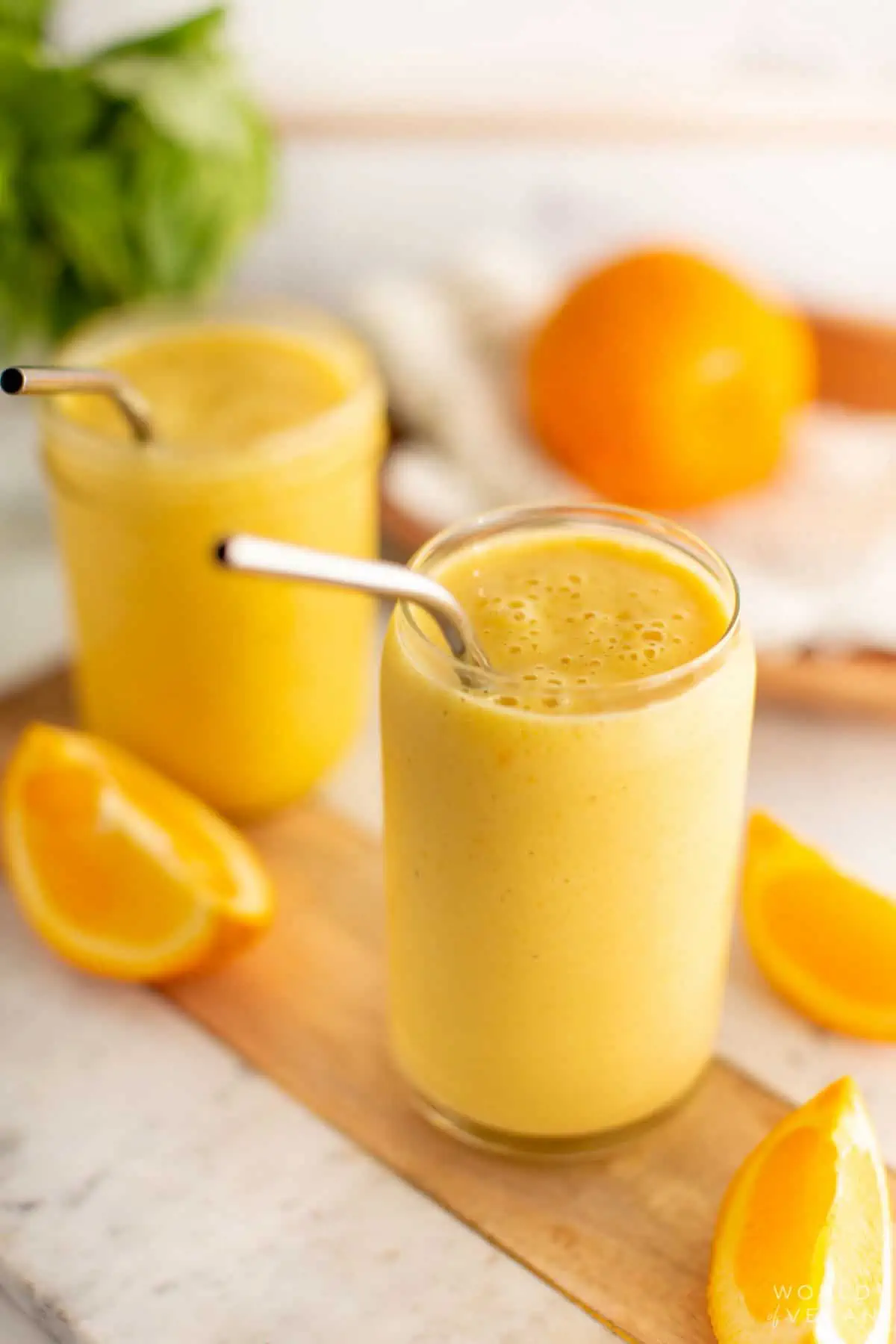 An orange juice smoothie in a glass, a healthy vegan snack idea.