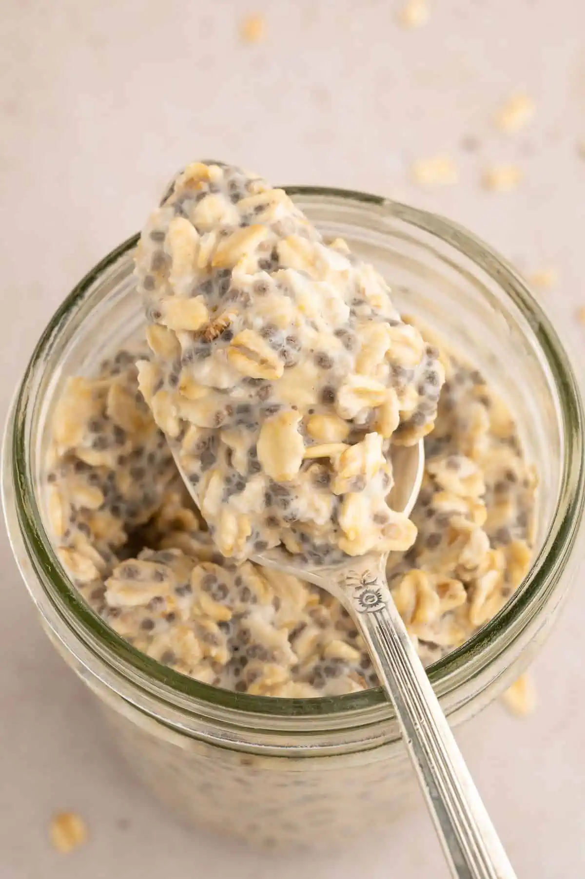 Overnight oats in a jar with a spoon resting on top holding a scoopful.
