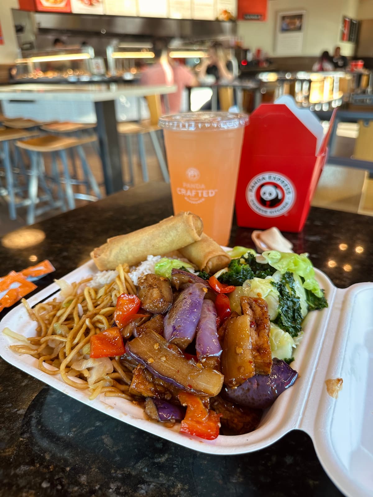 Panda Express Eggplant Tofu vegan menu item with beverage and take out container.