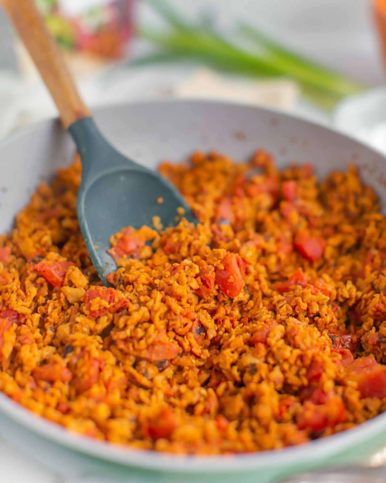 Vegan meatless crumbles with garlic and fire-roasted tomatoes cooked in a skillet.