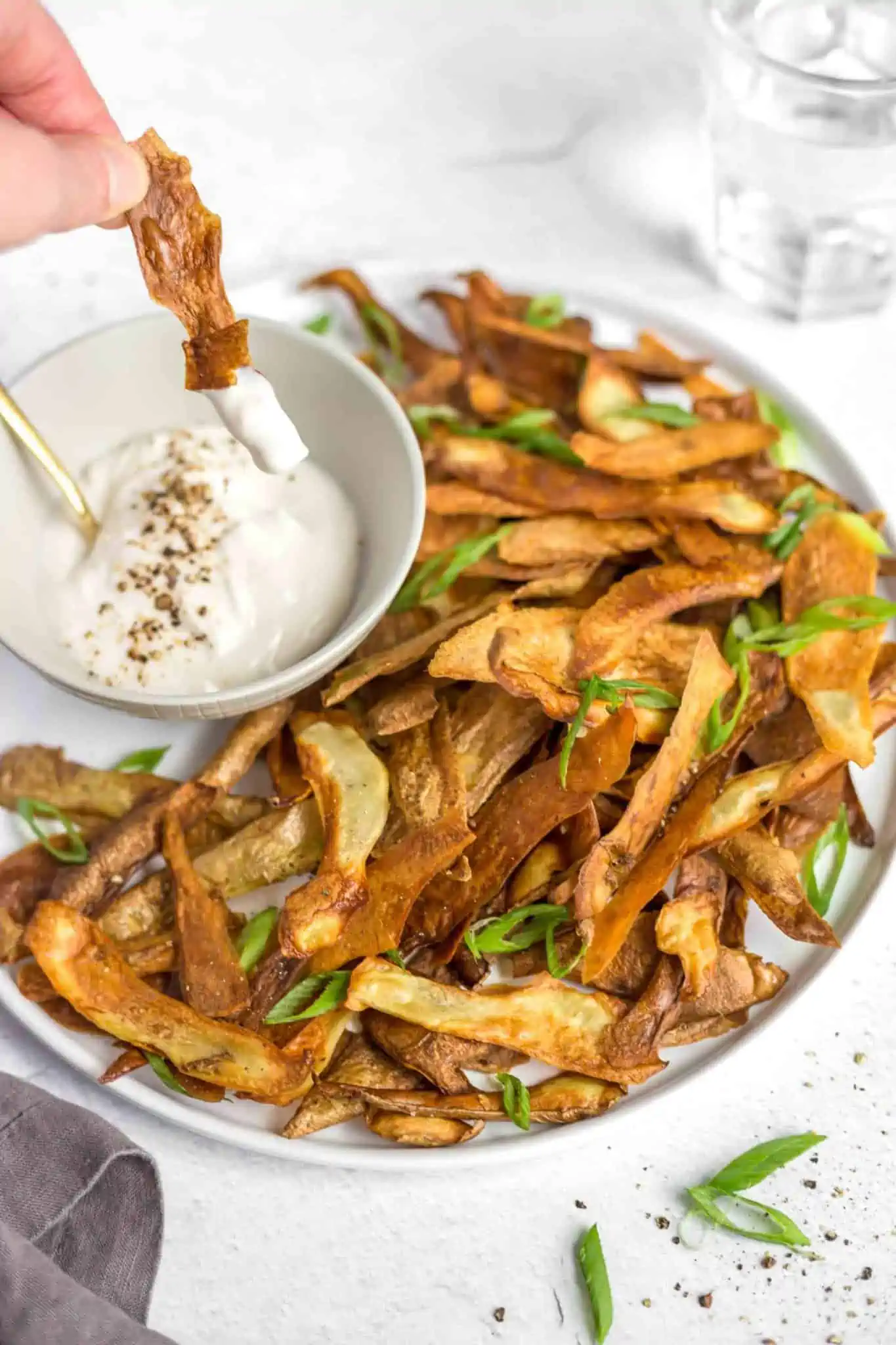 Crispy potato skin chips served with a side of vegan dip for the perfect game-day snack.