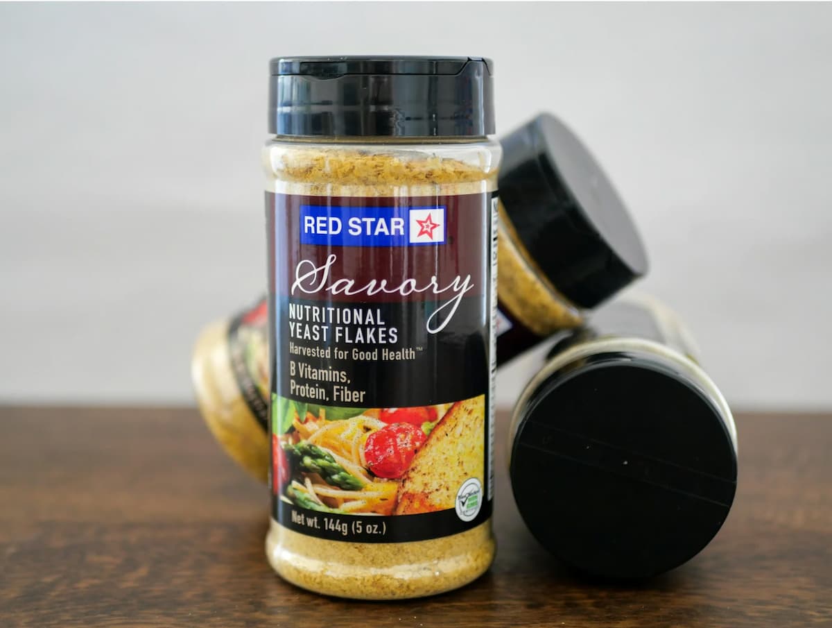 Three plastic canisters of Red Star Nutritional Yeast.