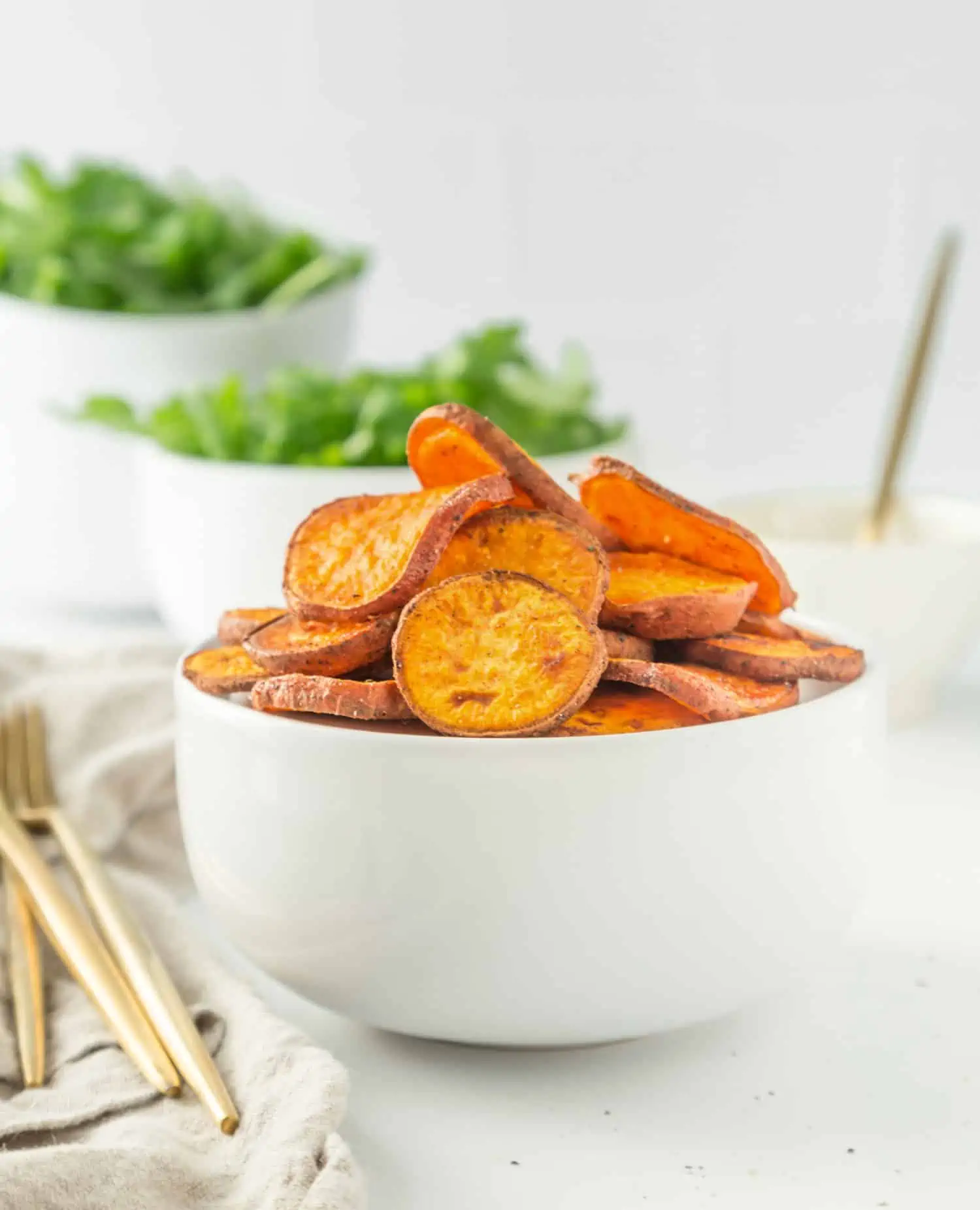 Sweet potato rounds slivers in a white bowl.
