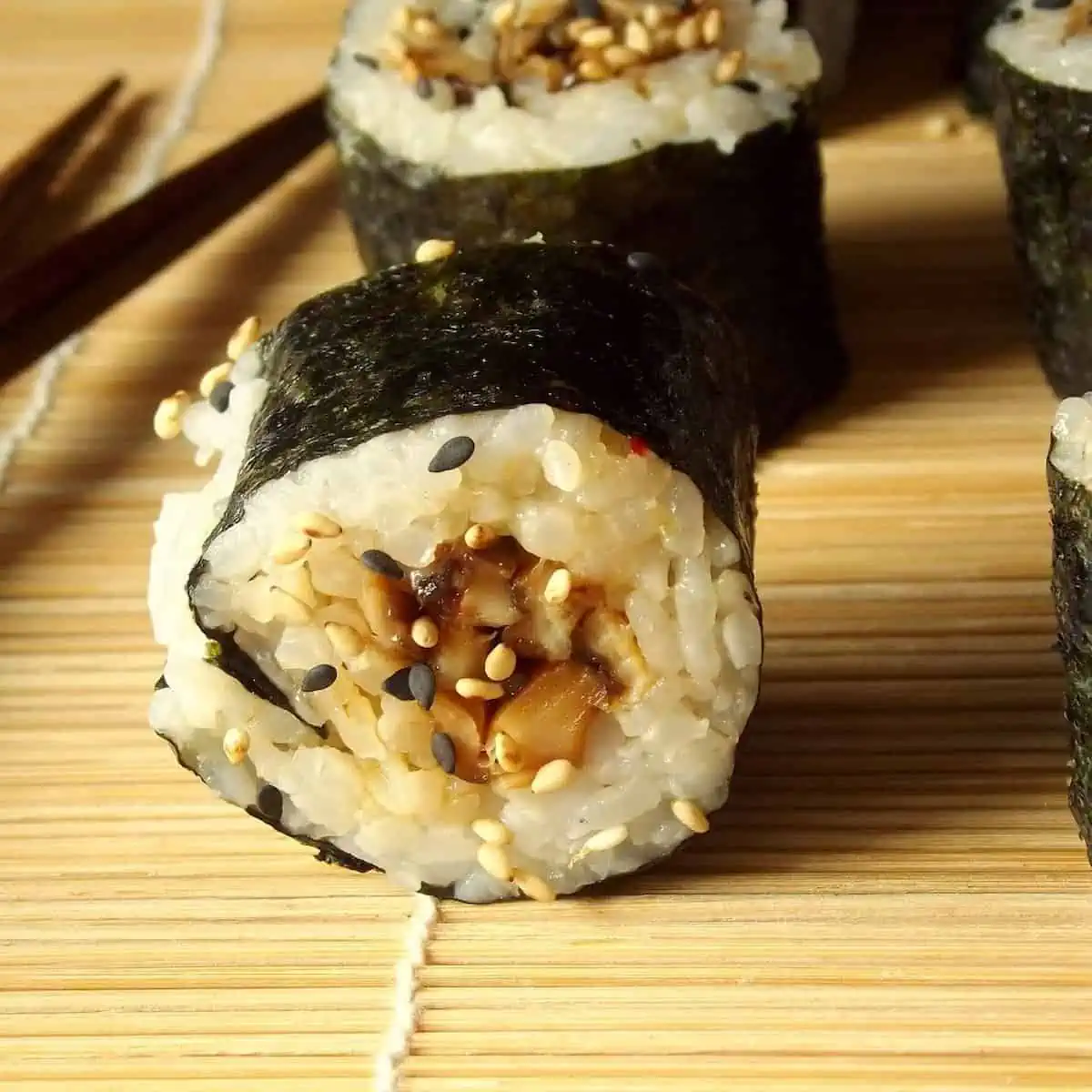 A shiitake sushi roll on a bamboo mat.