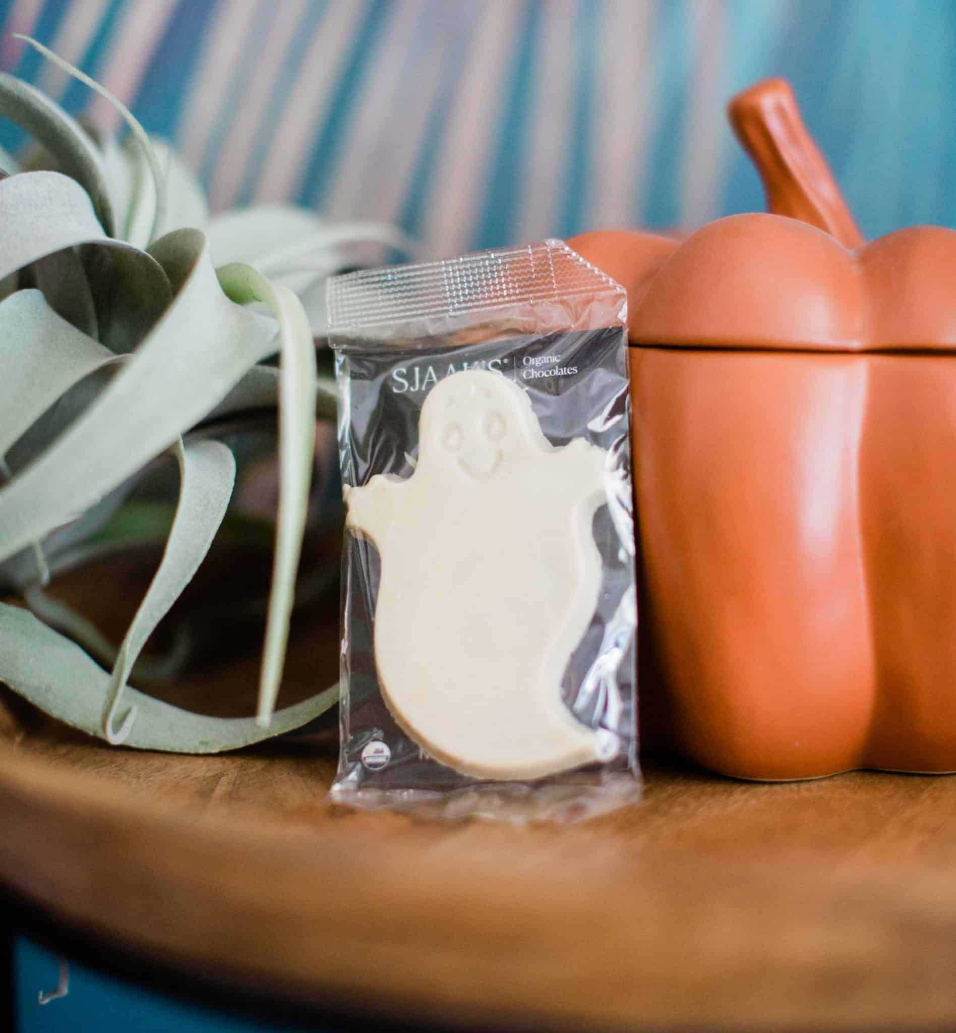 White vegan Halloween chocolate ghost from Sjaak’s surrounded by autumn decor.