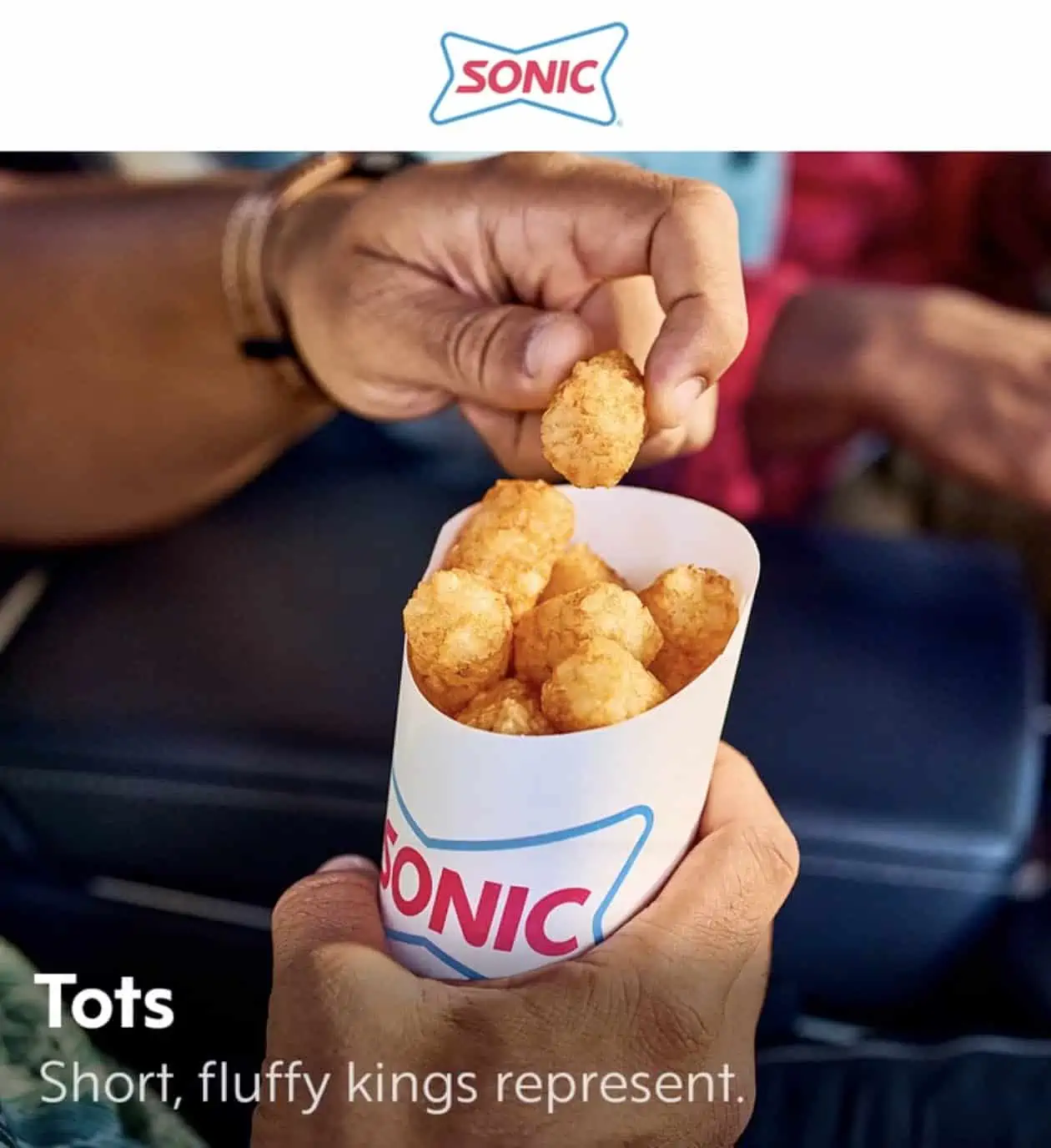 Hanh holding out sonic tater tots vegan side on menu
