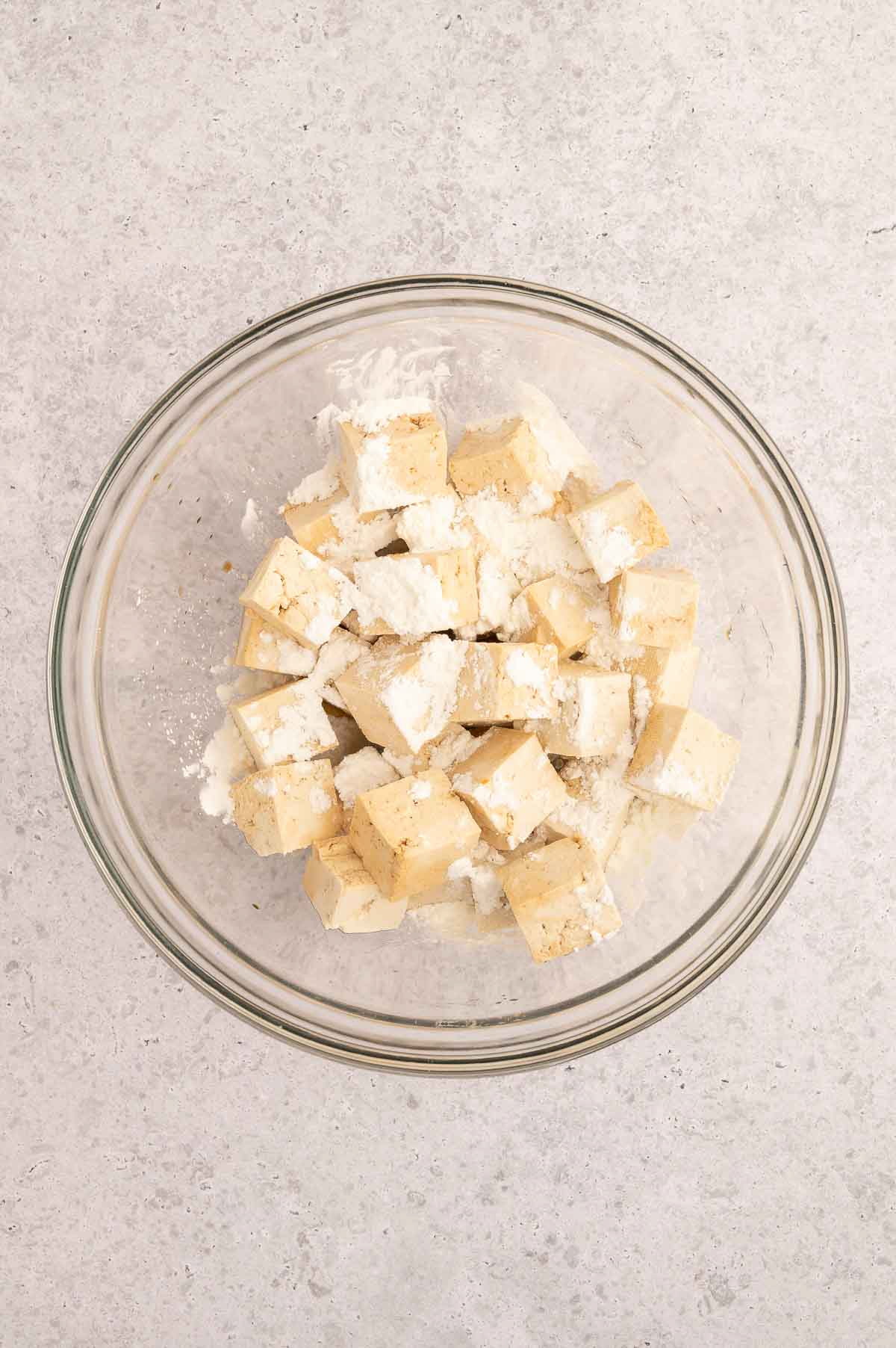 Cubed tofu in a glass bowl before mixing.