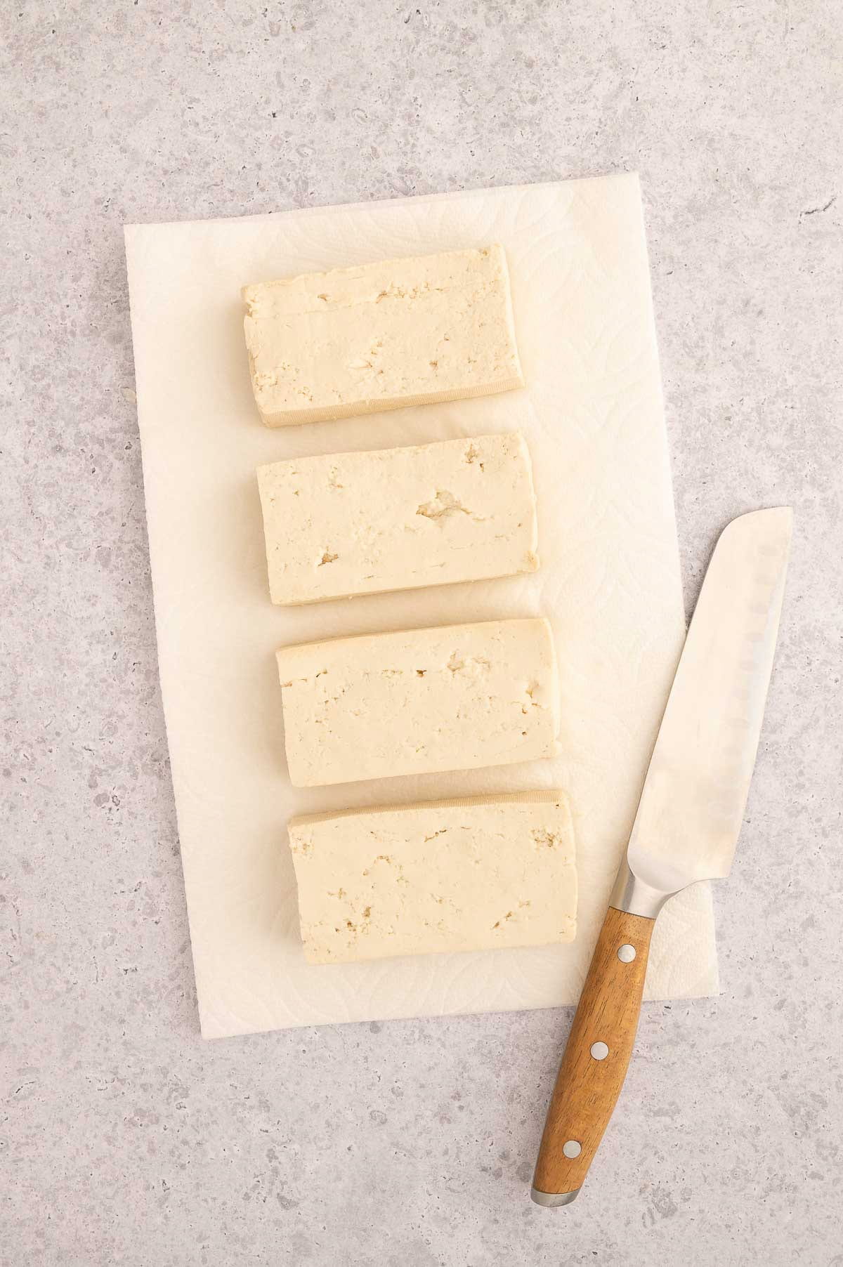 Cutting and preparing the tofu for this Thai tofu salad with peanut sauce and veggies.