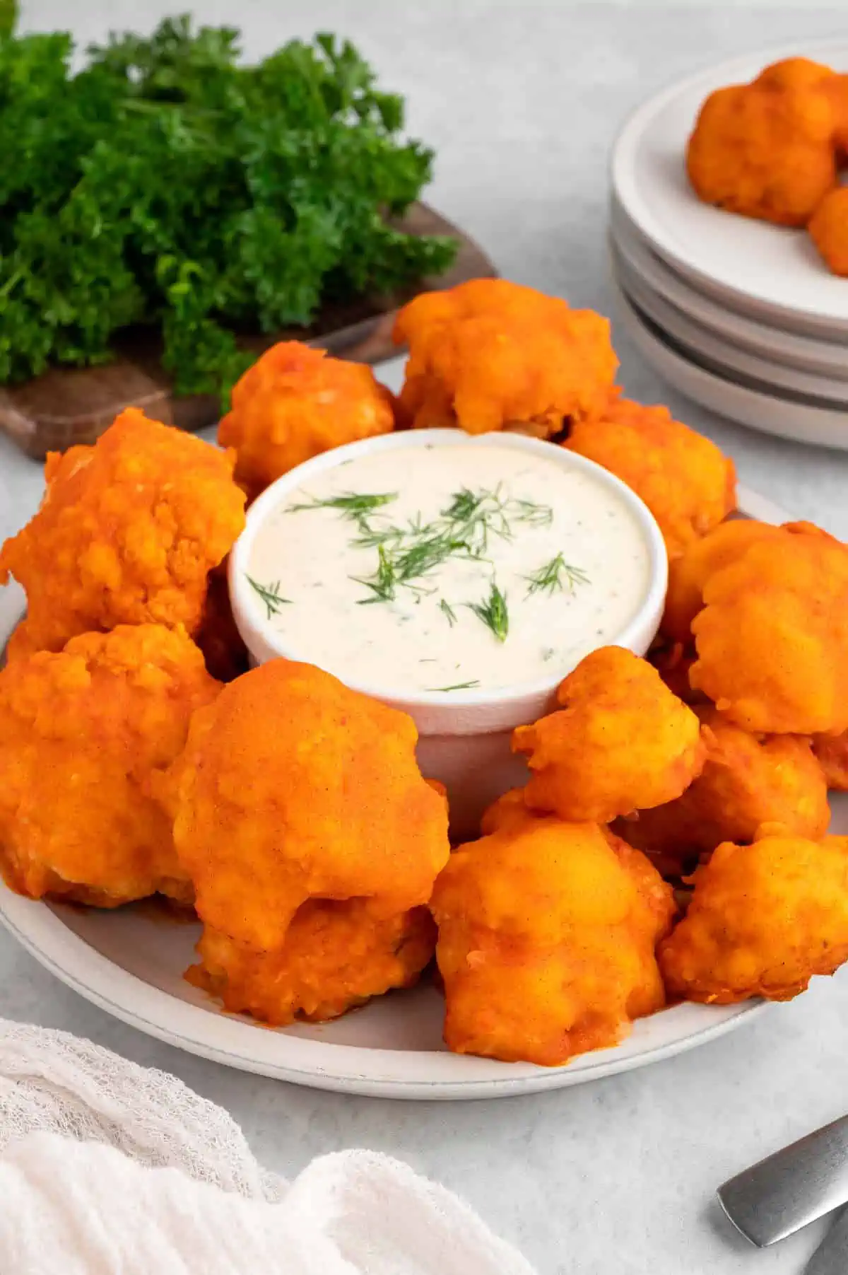 Vegan buffalo cauliflower wings on a plate with vegan ranch, crispy and spicy BBQ-ready snack.