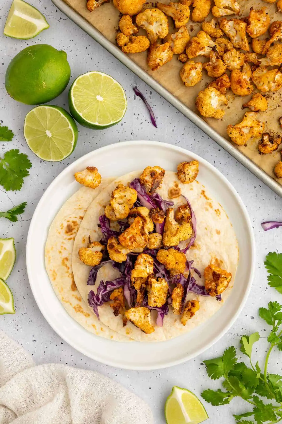 Soft tortillas topped with crunchy slaw and roasted cauliflower, ready for assembly.