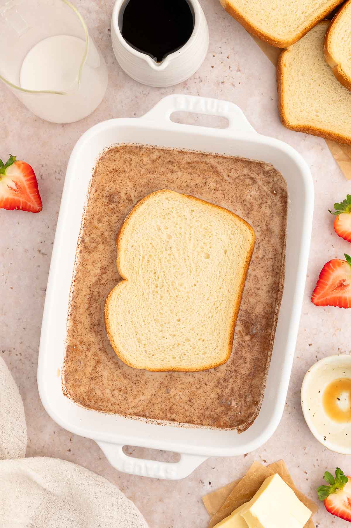 A piece of bread being coated to make vegan French toast.