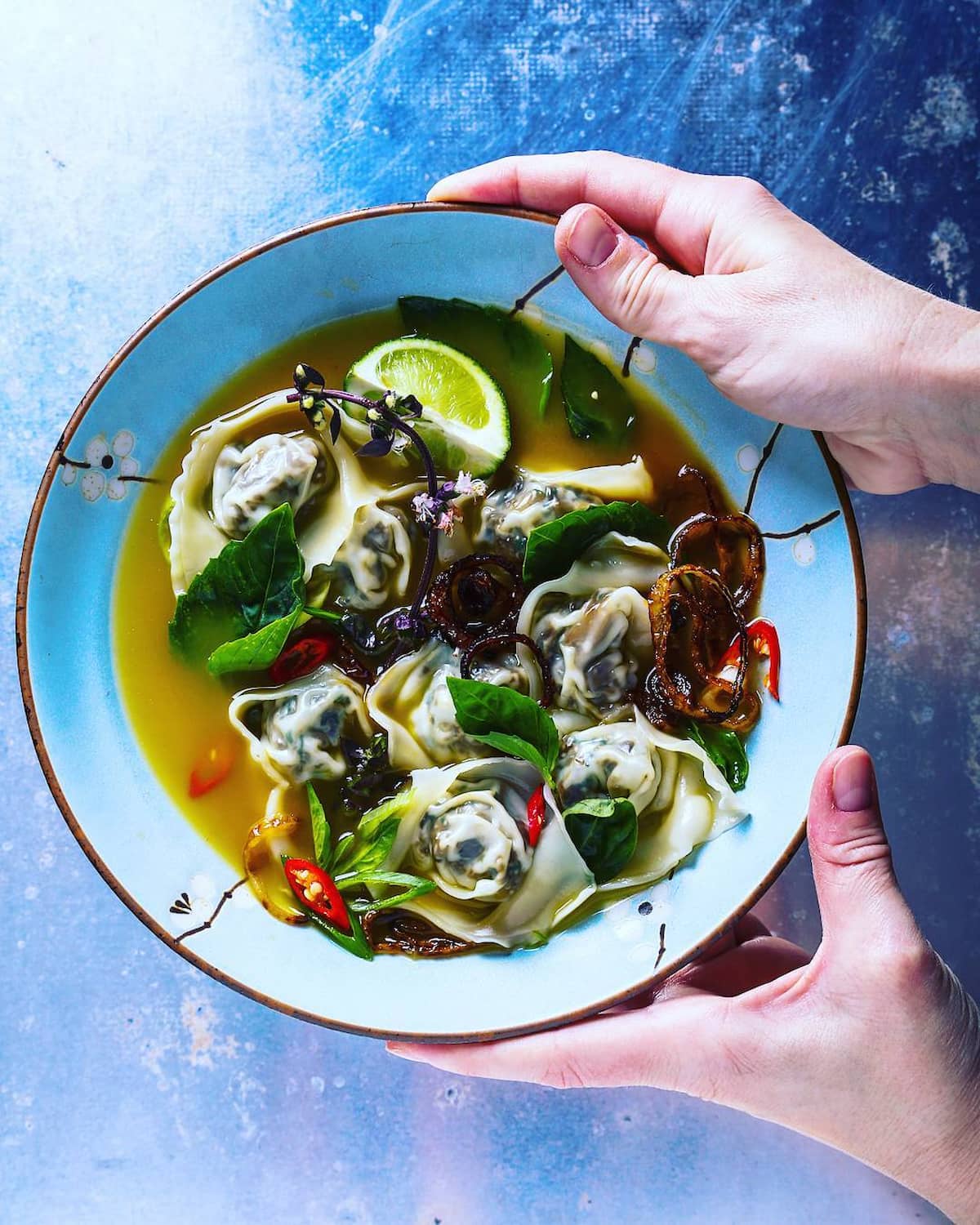 Vegan wonton soup with roasted ginger broth and Thai herbs.