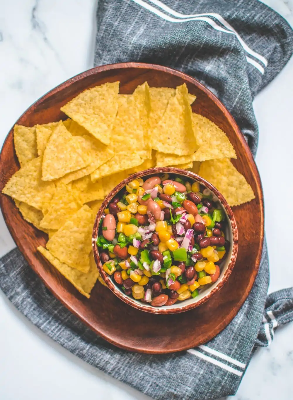Texas caviar with tortilla chips on a plate.