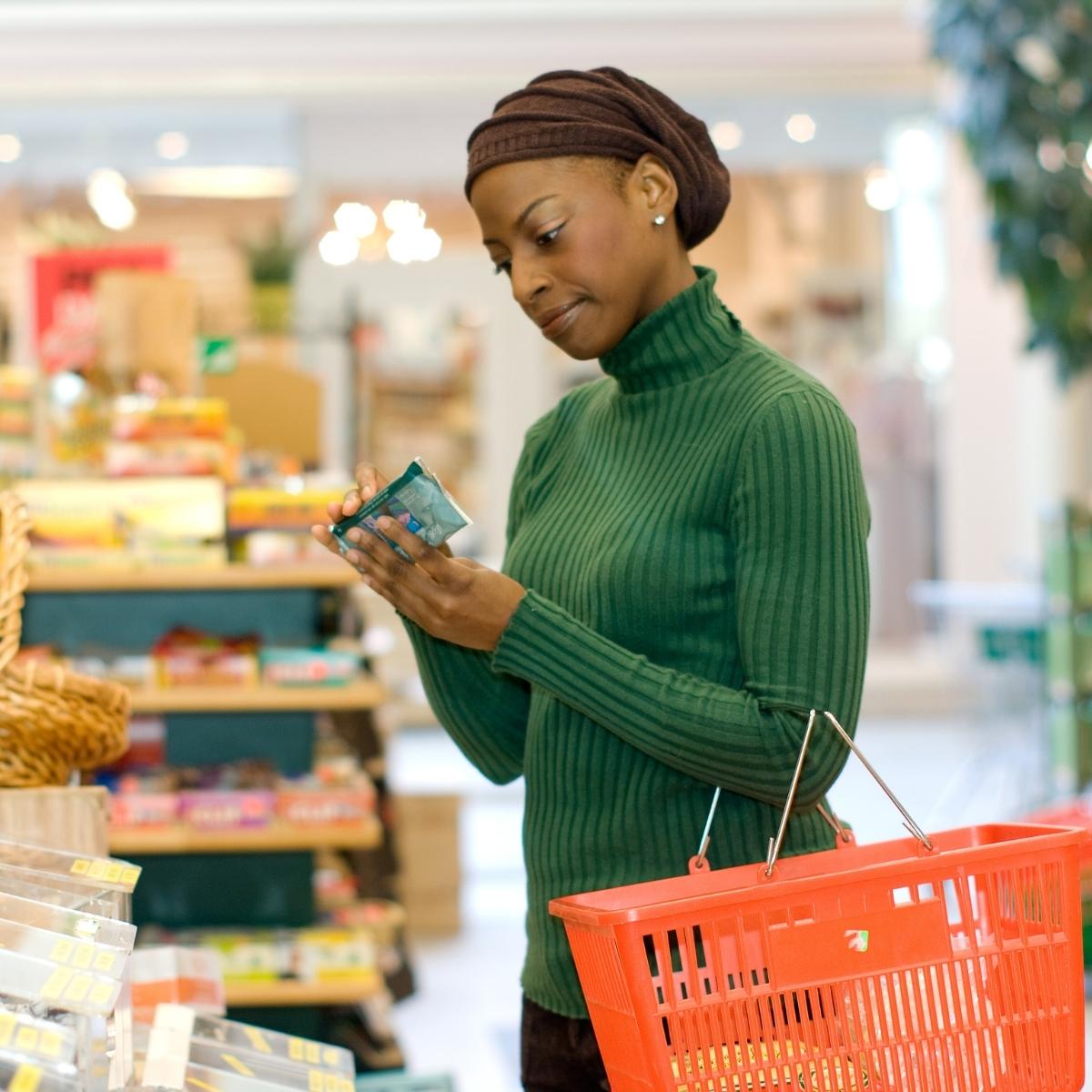 A woman reading a label in the grocery store.