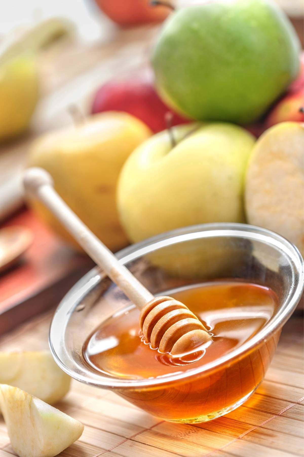 Sliced apples with vegan honey and a honey dipper – a traditional Rosh Hashanah pairing made plant-based.