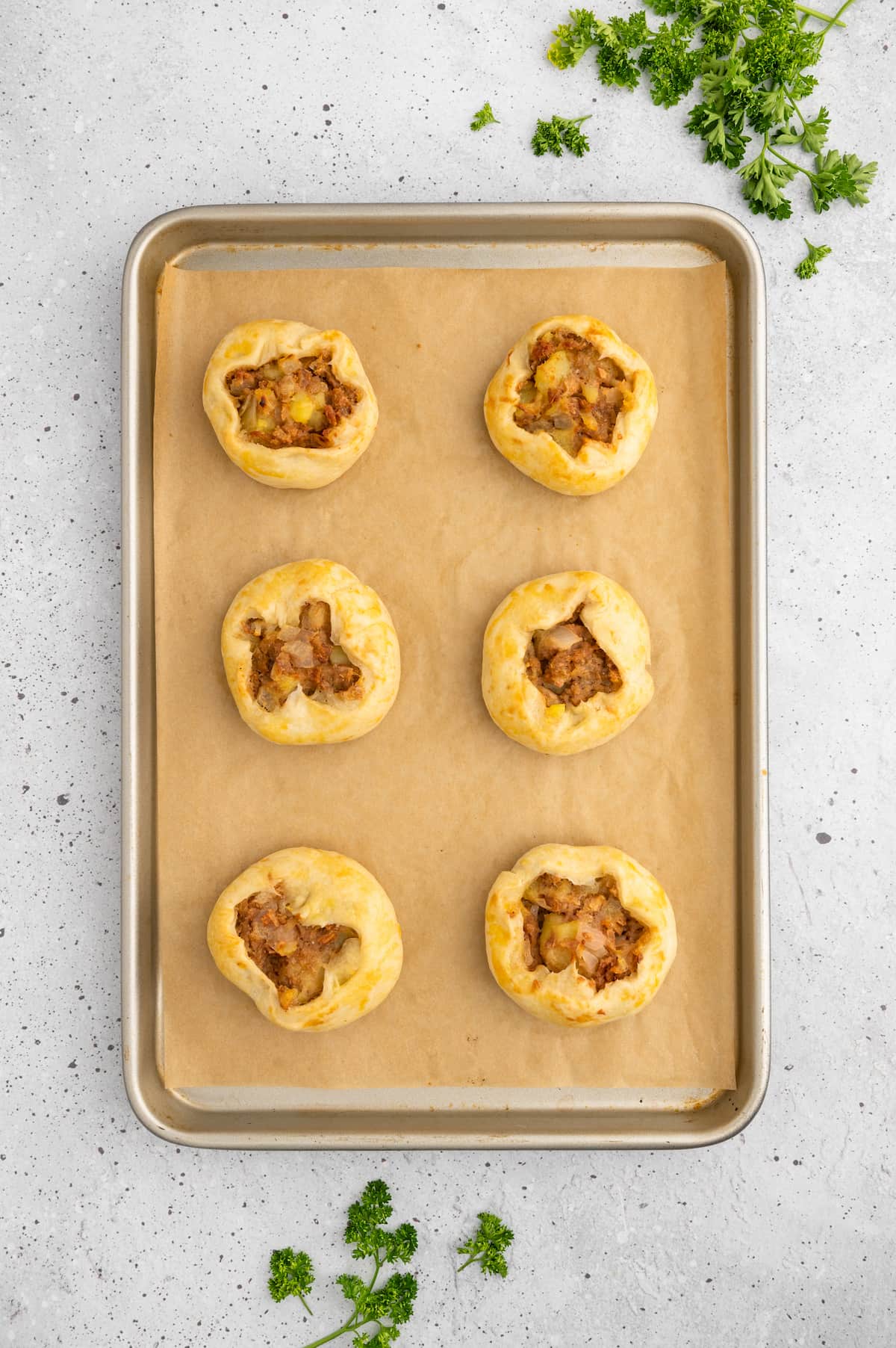 The finished baked knishes on a baking tray.
