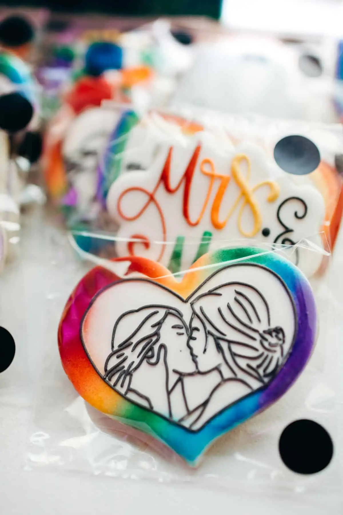 Rainbow heart frosted vegan wedding cookies made by Bee Loved Cookie Co celebrating same-sex couple.