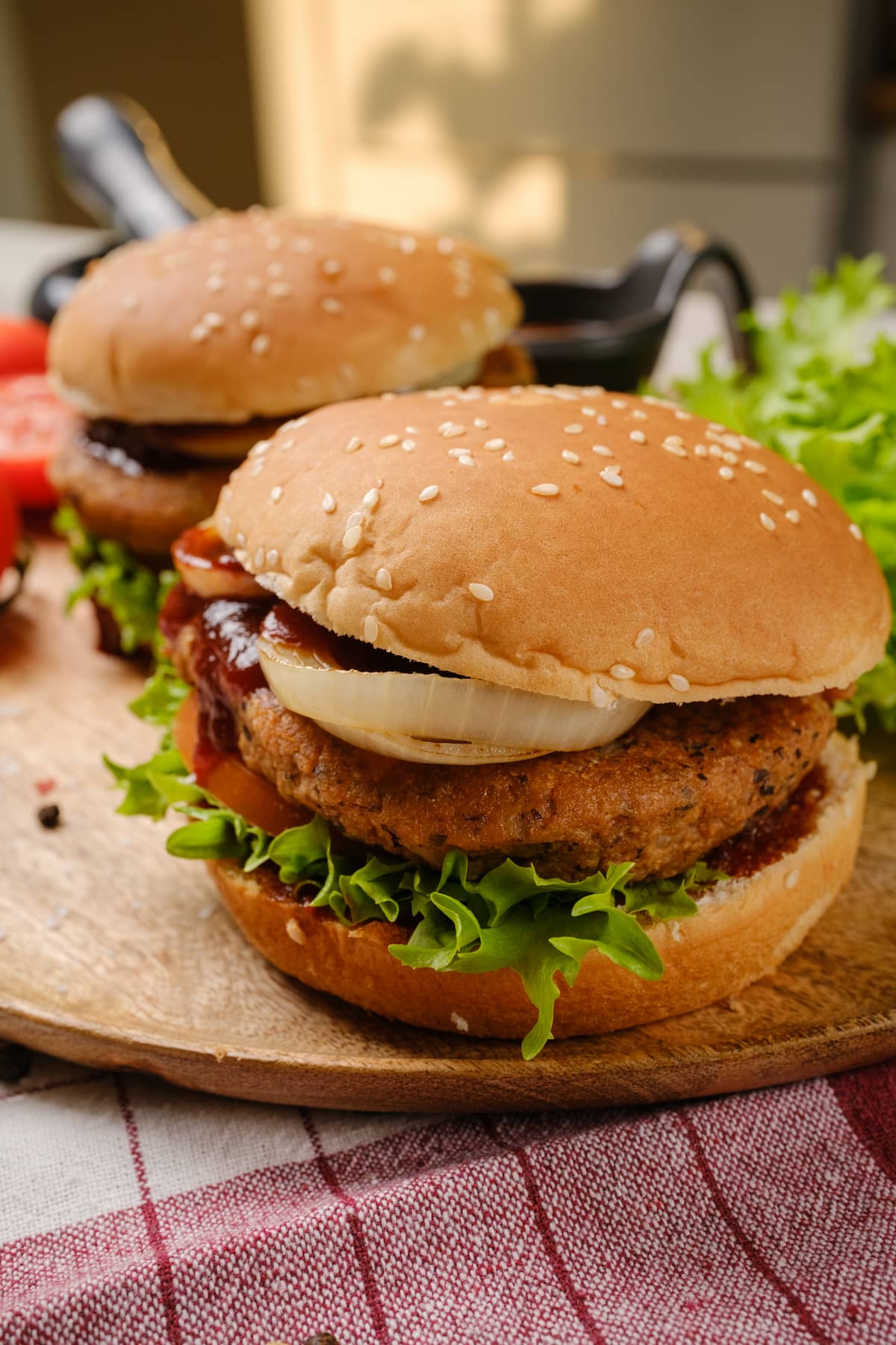 A loaded vegan burger with lettuce, tomato, pickles, and a toasted bun, perfect for Super Bowl Sunday.