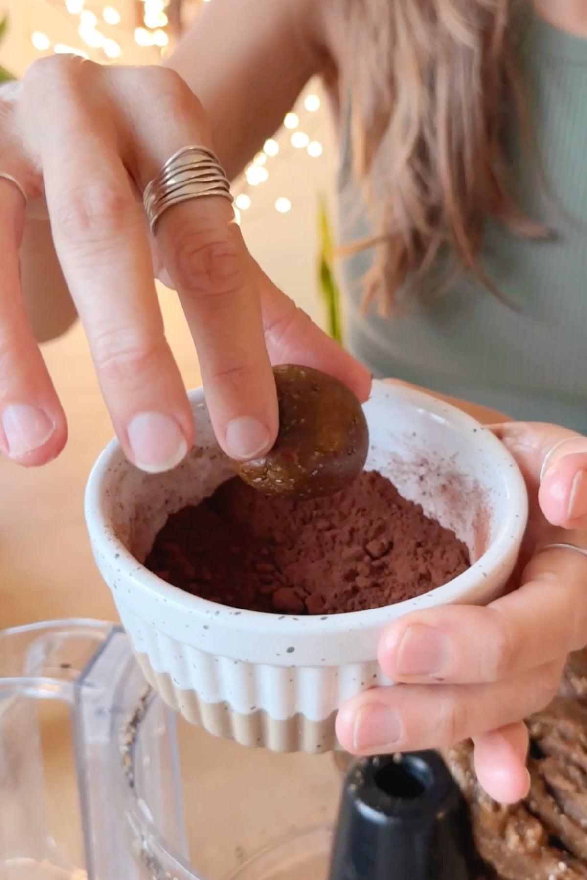 Rolling the truffle dough into cocoa powder to coat it.