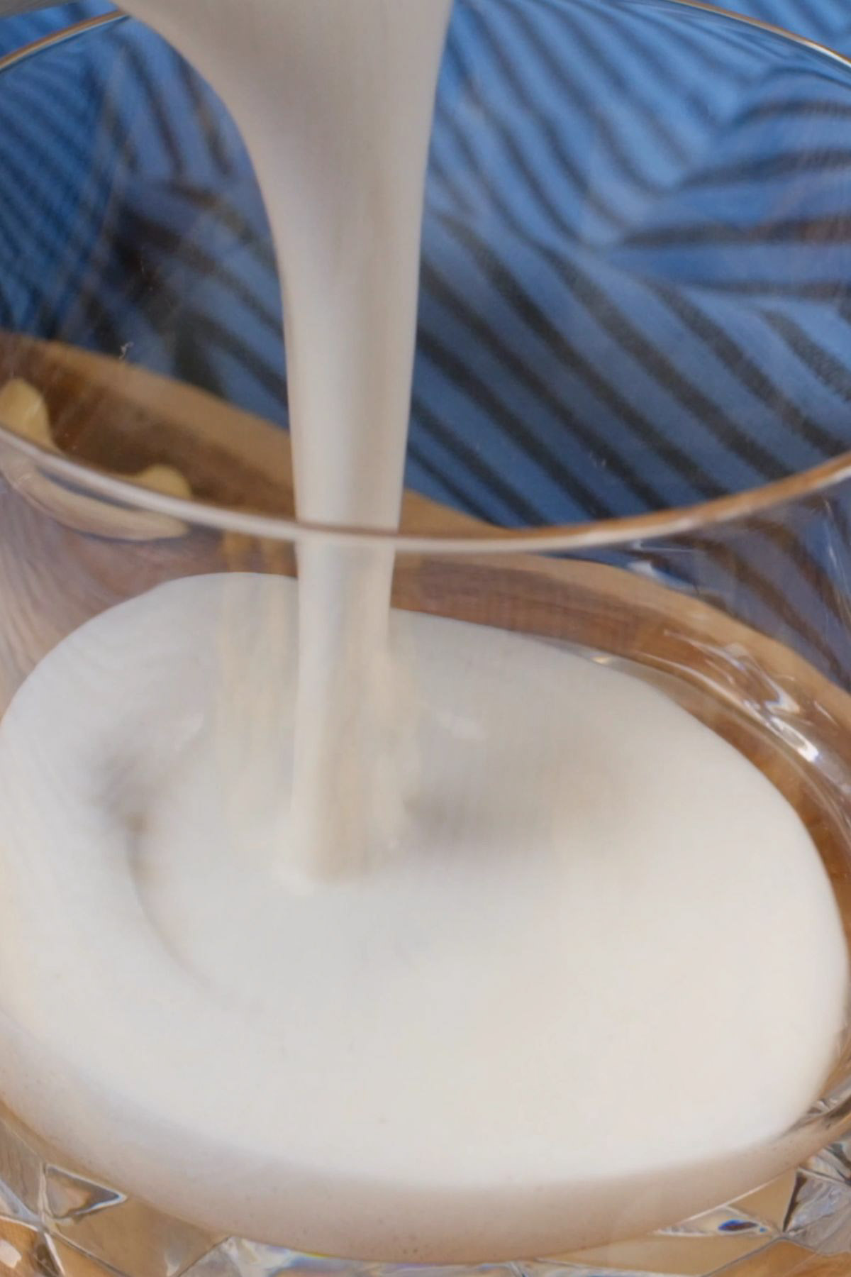Cashew milk being poured into a glass.
