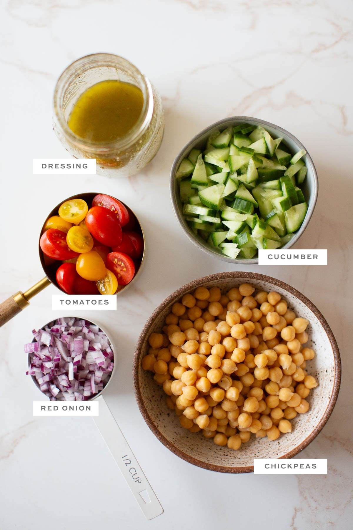 Gathered ingredients for this chickpea orzo salad, measured out and labeled.