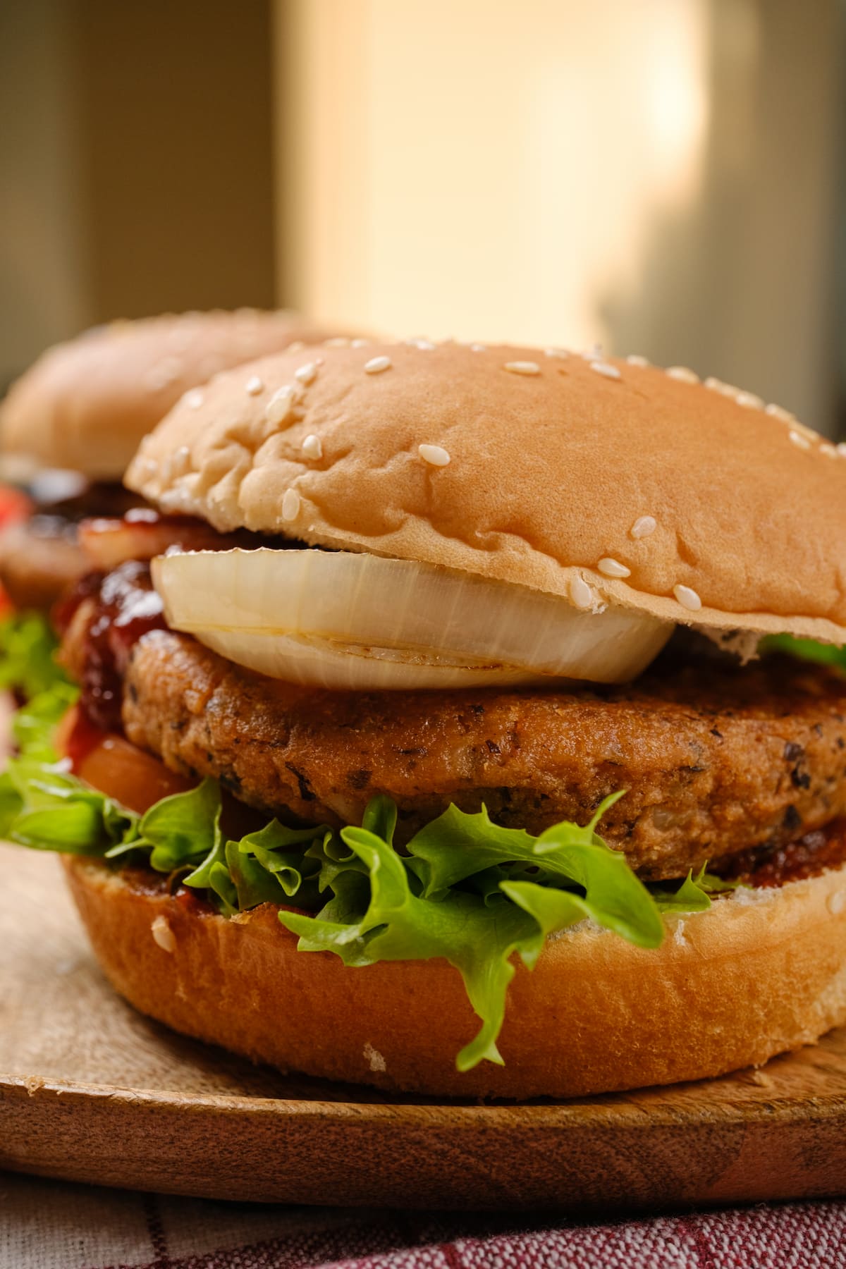 Chipotle black bean burger stacked with lettuce, tomato, and vegan BBQ sauce in a toasted bun.