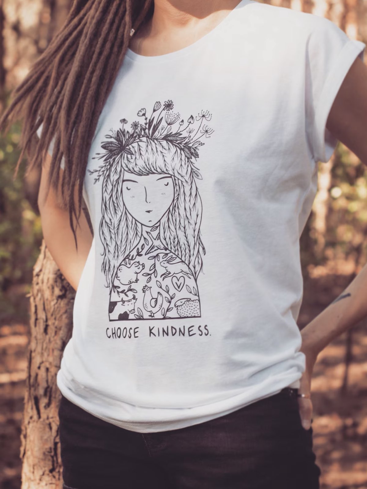 A woman in the woods wearing a vegan t-shirt that says "Choose Kindness" by Woodland Factory on Etsy.