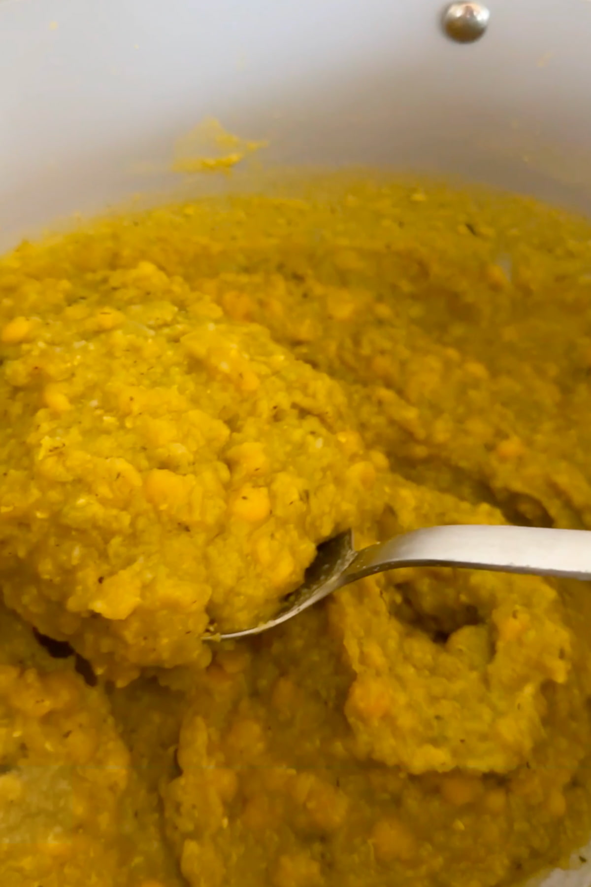 A large soup pot filled with cooked spilt pea mason jar soup.