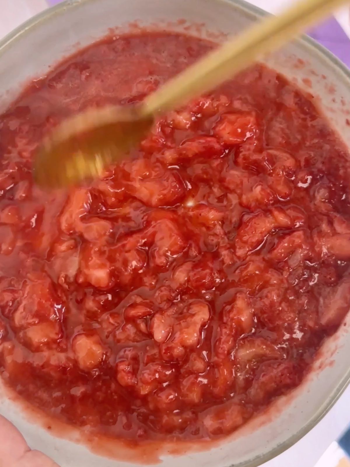 A dish of strawberry sauce to add to the popsicles.