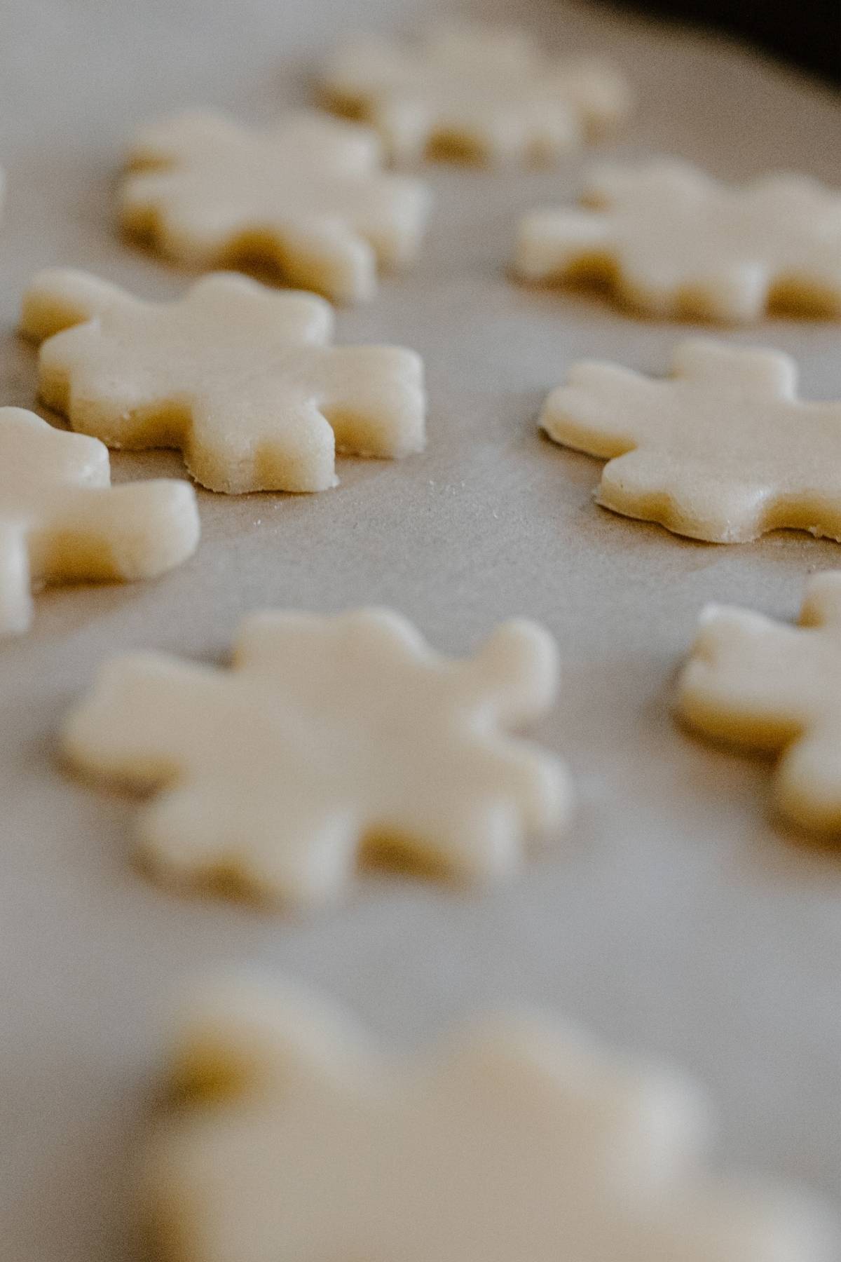 Cookie dough cut into shapes on a baking sheet.