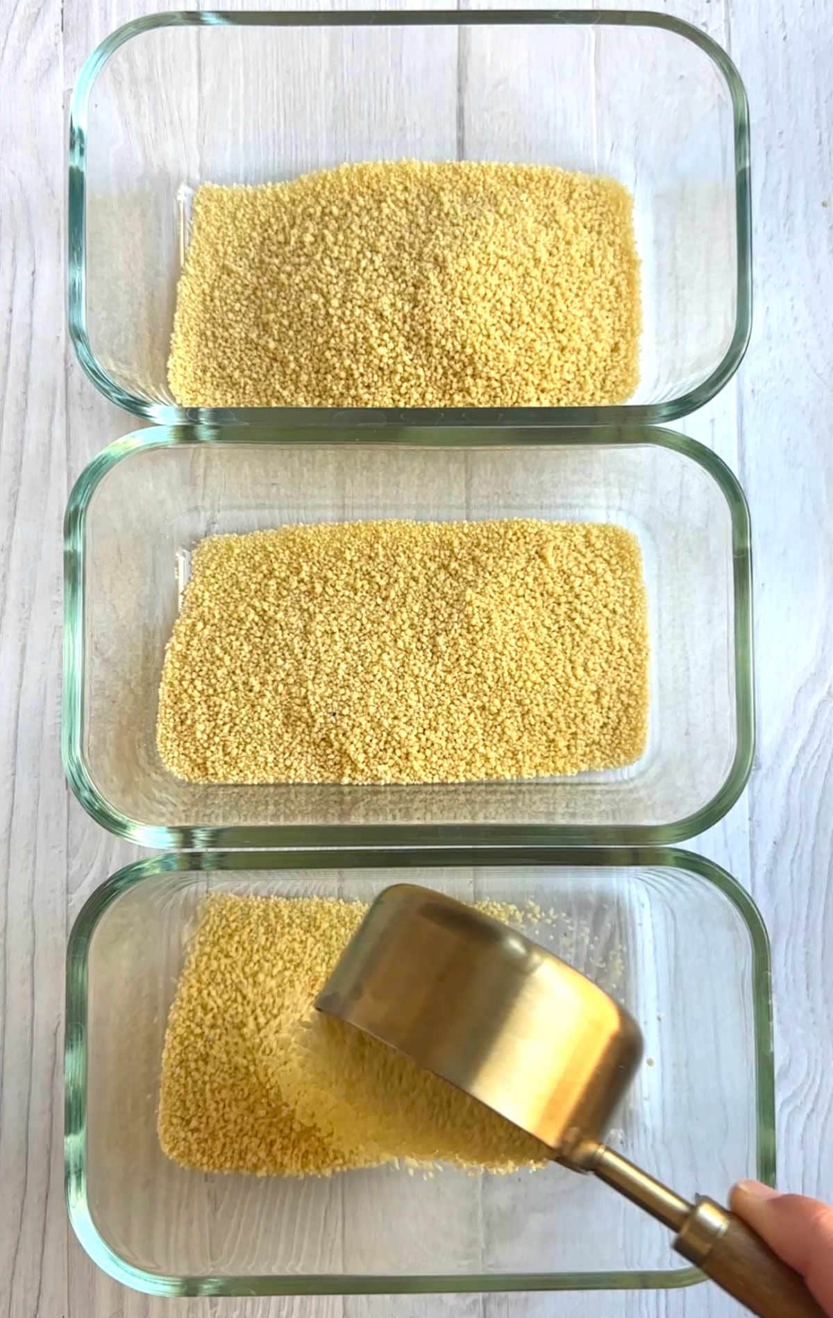Dry instant couscous added to the bottom of meal prep containers.