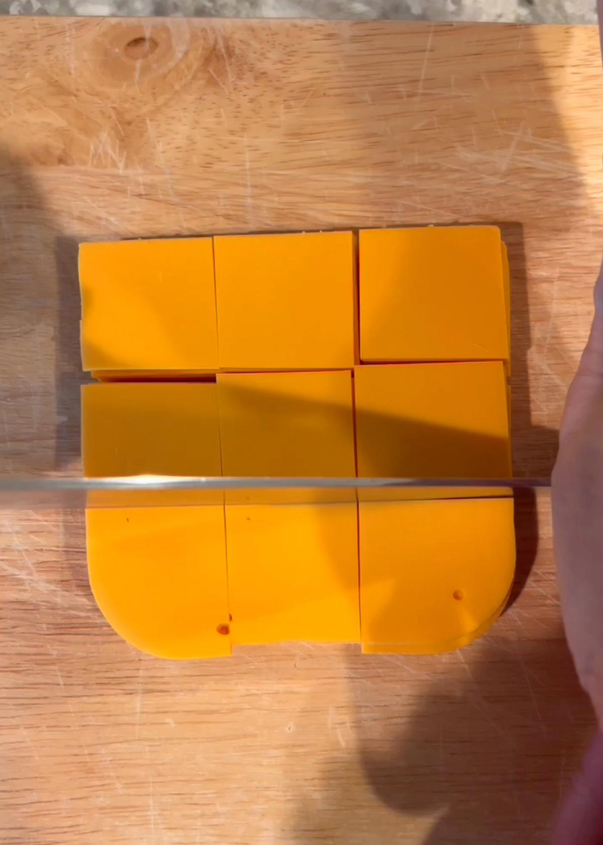 Cutting vegan cheese slices to make vegan cheese crackers.