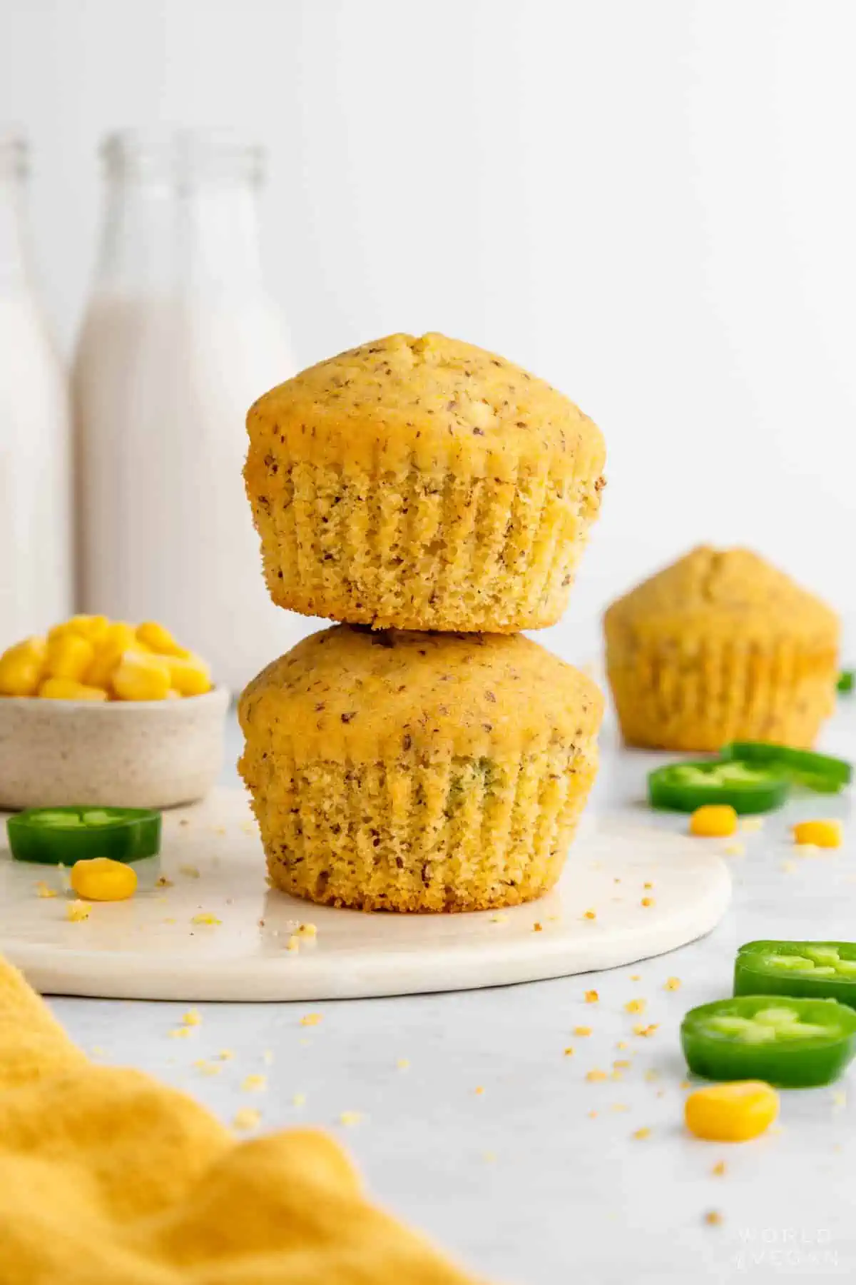 Golden vegan cornbread muffins stacked on a plate, dairy-free and fluffy.