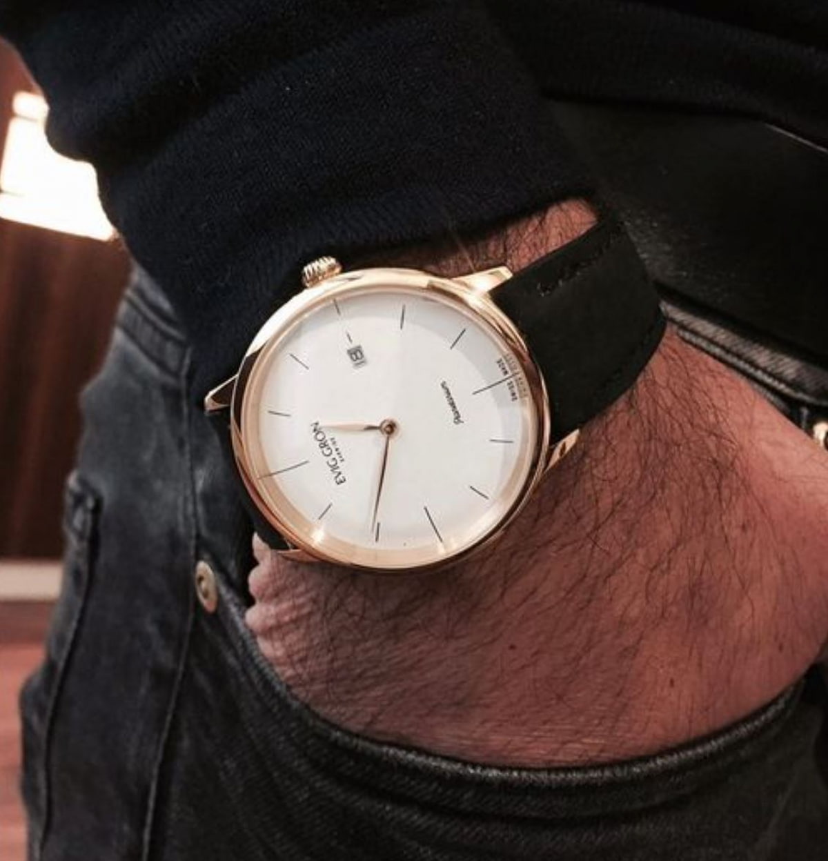 A hand in a pocket wearing a Evig Grön brand vegan watch.