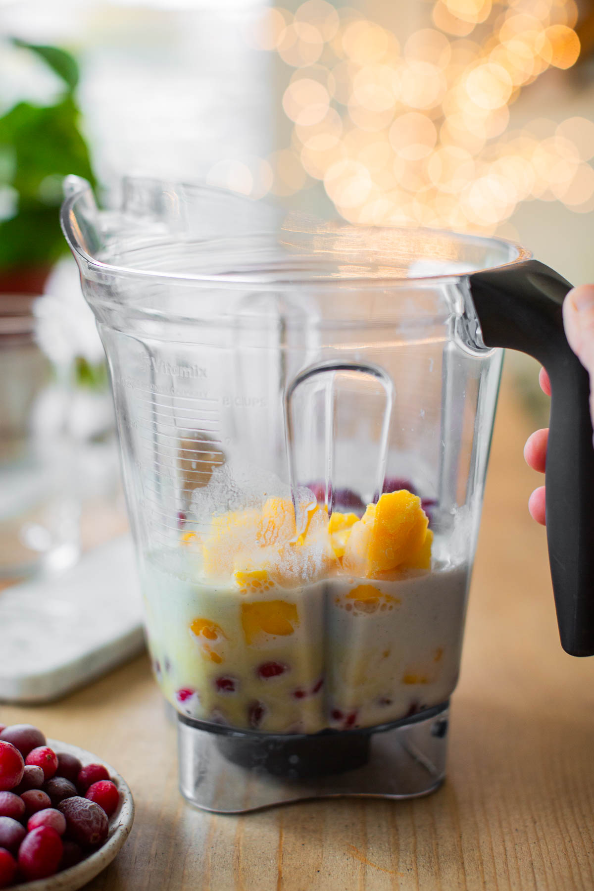 The ingredients for this cranberry smoothie added to a blender pitcher.