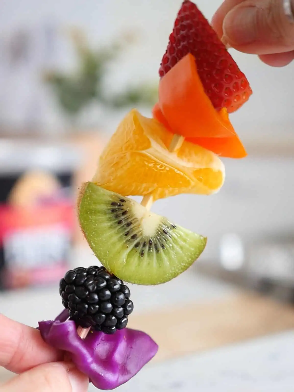 A fruit skewer, threaded with lots of colorful produce.