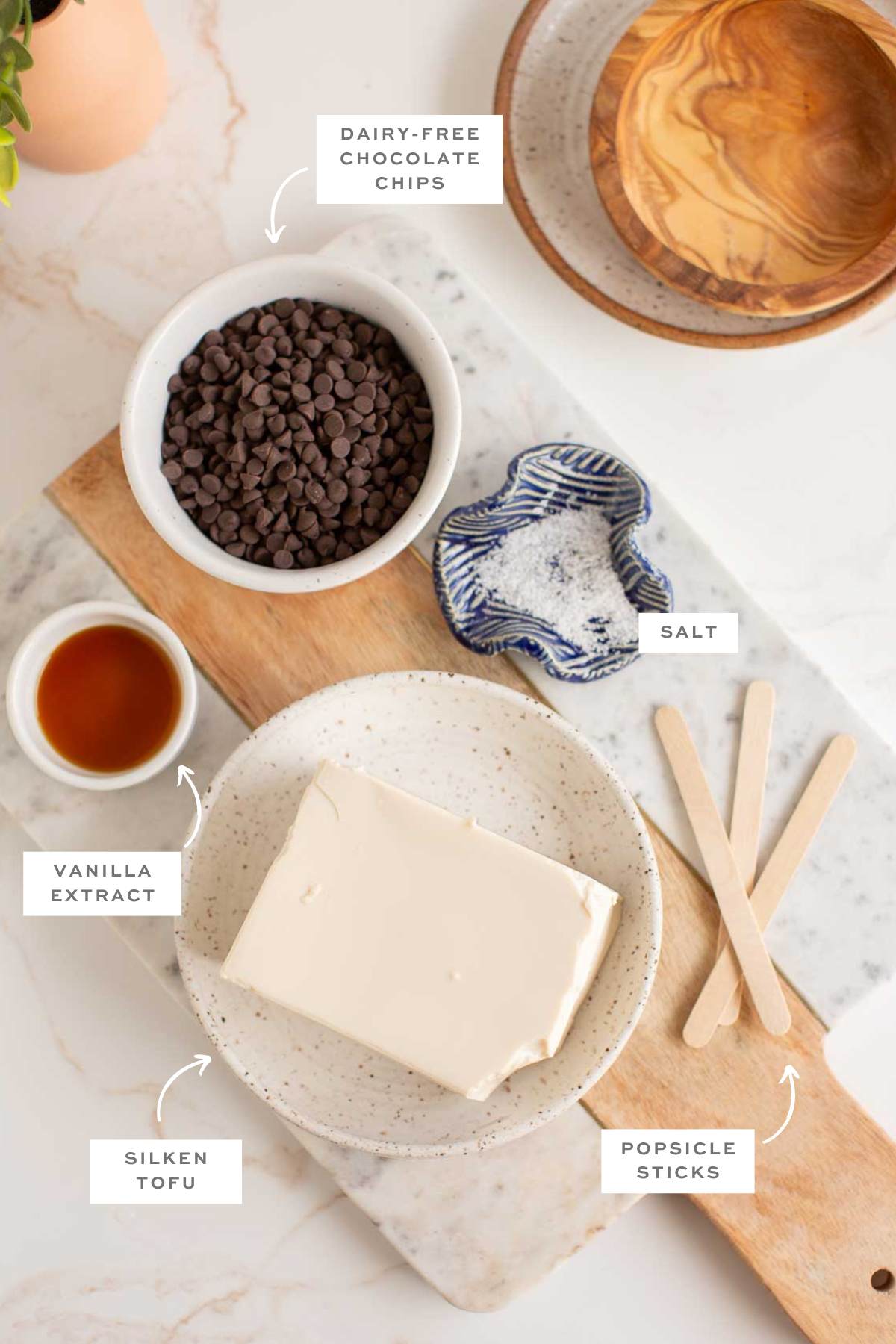 Gathered ingredients for these fudgesicle popsicles in individual bowls with labels.