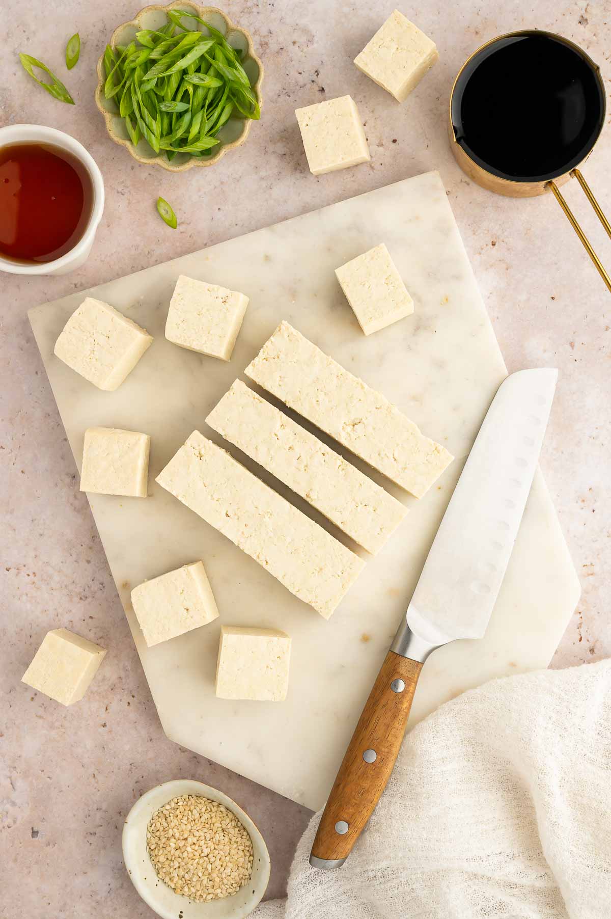 Tofu cubed on a cutting board.