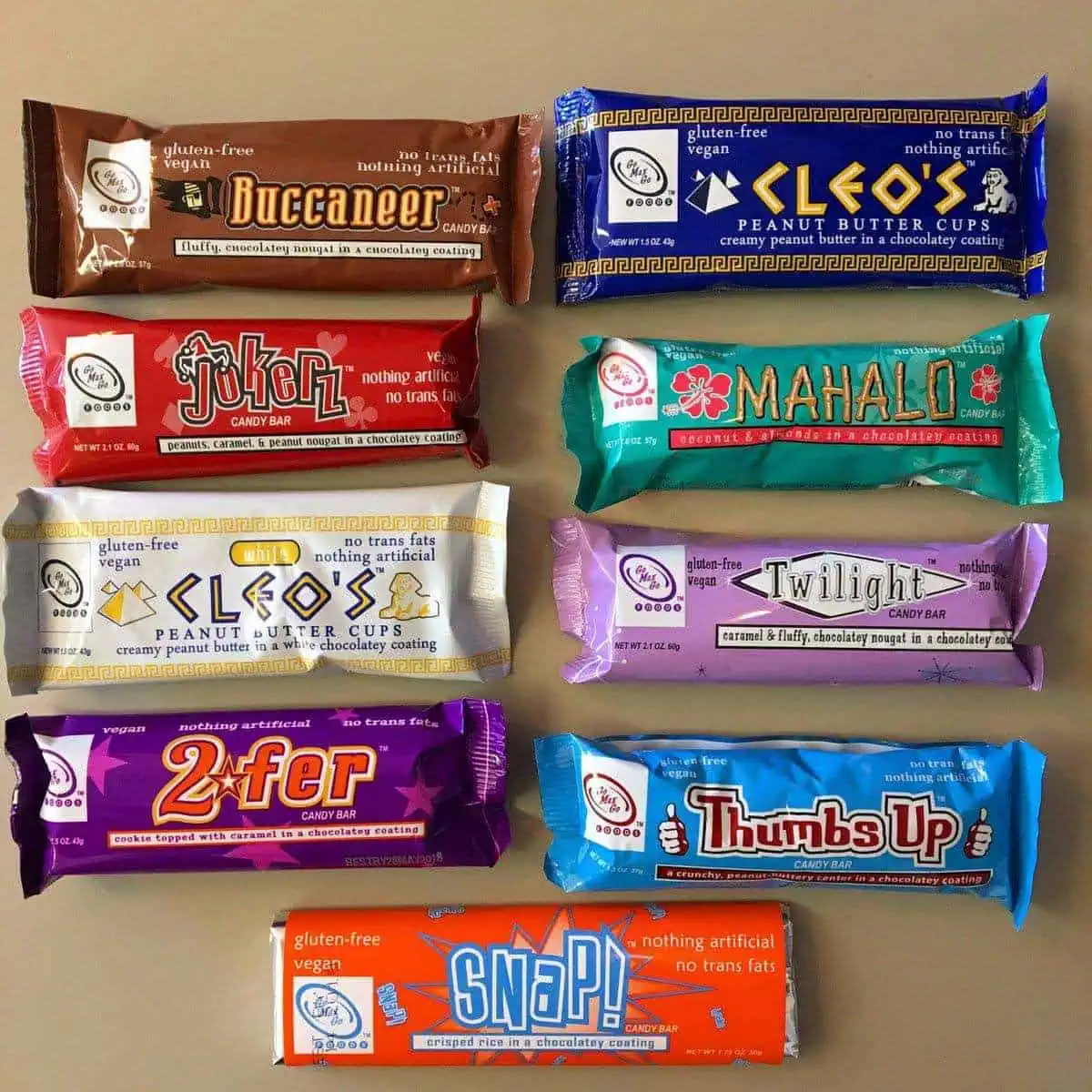 Nine vegan candy bars by Go Max Go Foods laid out on a table.